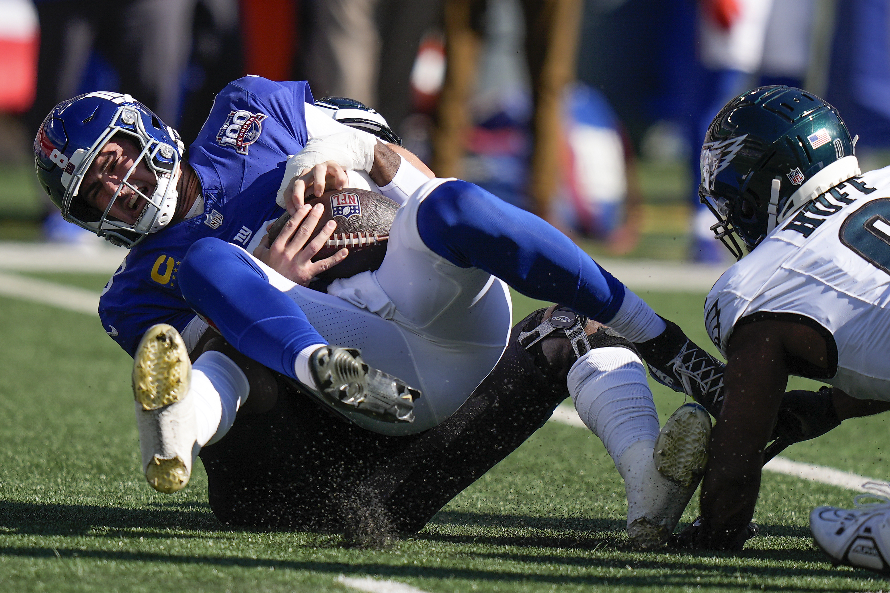 New York Giants quarterback Daniel Jones (8) is sacked by Philadelphia Eagles linebacker Josh Sweat (19) during the first quarter of an NFL football game, Sunday, Oct. 20, 2024, in East Rutherford, N.J.