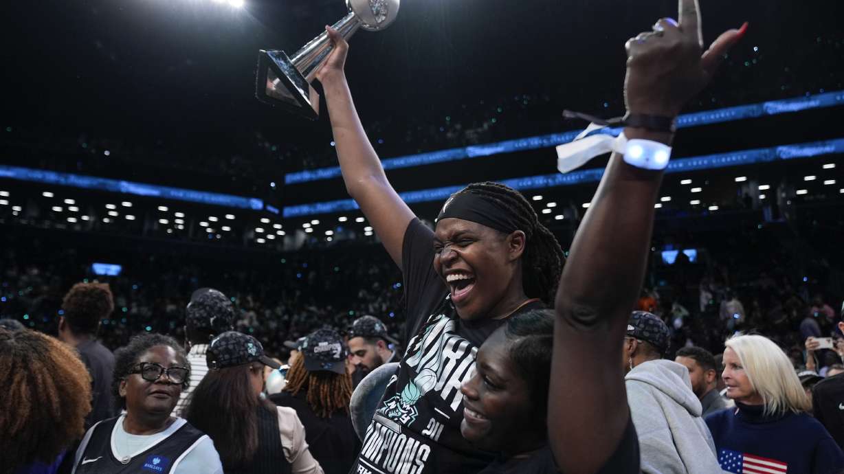 New York Liberty forward Jonquel Jones, left, holds up the MVP award after the Liberty defeated the Minnesota Lynx in Game 5 of the WNBA basketball final series, Sunday, Oct. 20, 2024, in New York.