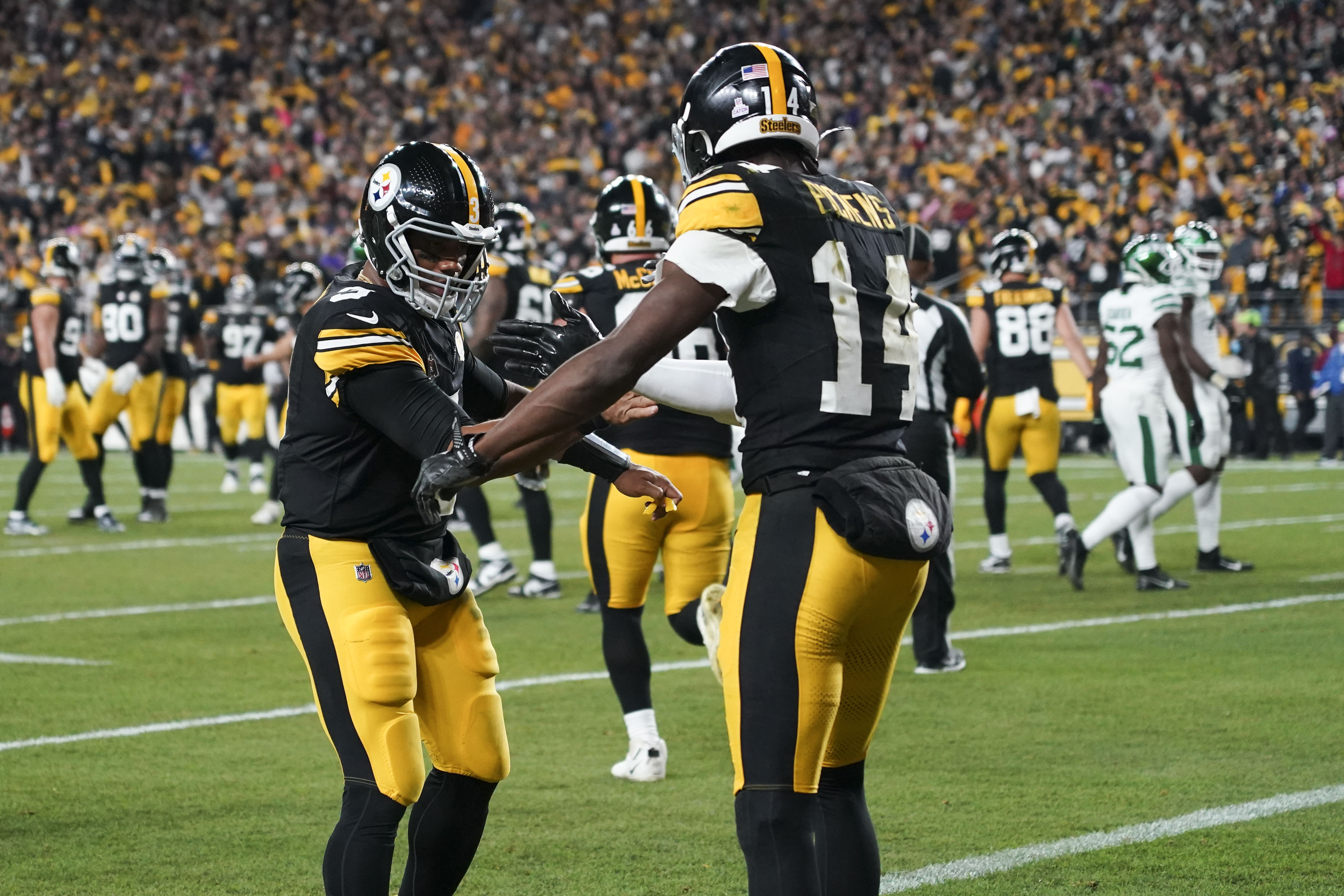 Pittsburgh Steelers wide receiver George Pickens (14) celebrates his touchdown reception against New York Jets with Pittsburgh Steelers quarterback Russell Wilson (3) the first half of an NFL football game in Pittsburgh, Sunday, Oct. 20, 2024.