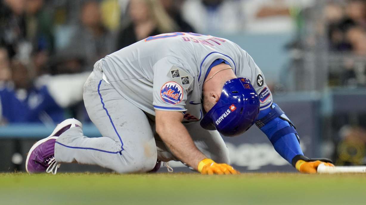 New York Mets' Pete Alonso reacts after getting hit with a foul ball against the Los Angeles Dodgers during the eighth inning in Game 6 of a baseball NL Championship Series, Sunday, Oct. 20, 2024, in Los Angeles.