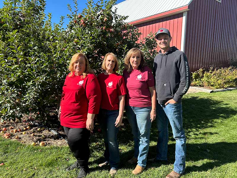 Jeanne Isom, second from right, with her son, Benson, right, and other extended family members. She planted 200 apple trees in 1994 and never imagined it would turn into a thriving fruit farm.