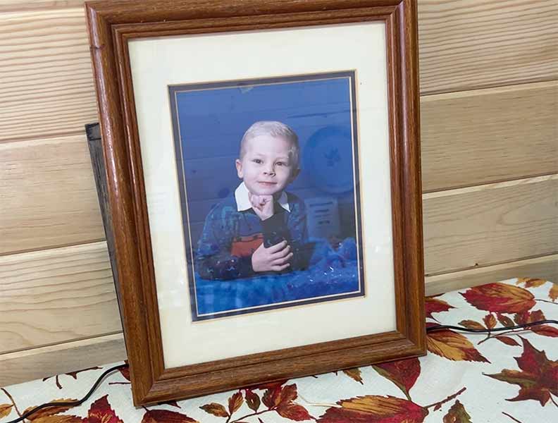 A photo of Justin Isom is displayed in the red barn at Isom Fruit Farm.