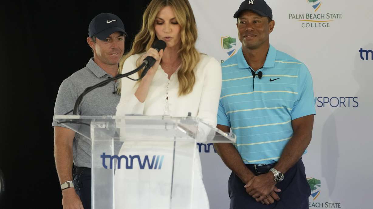 Host Erin Andrews, center, introduces golfers Tiger Woods, right, and Rory McIlroy during a news conference announcing the future home of TGL, a new tech-infused, team golf league, Tuesday, Feb. 21, 2023, on the campus of Palm Beach State College in Palm Beach Gardens, Fla.