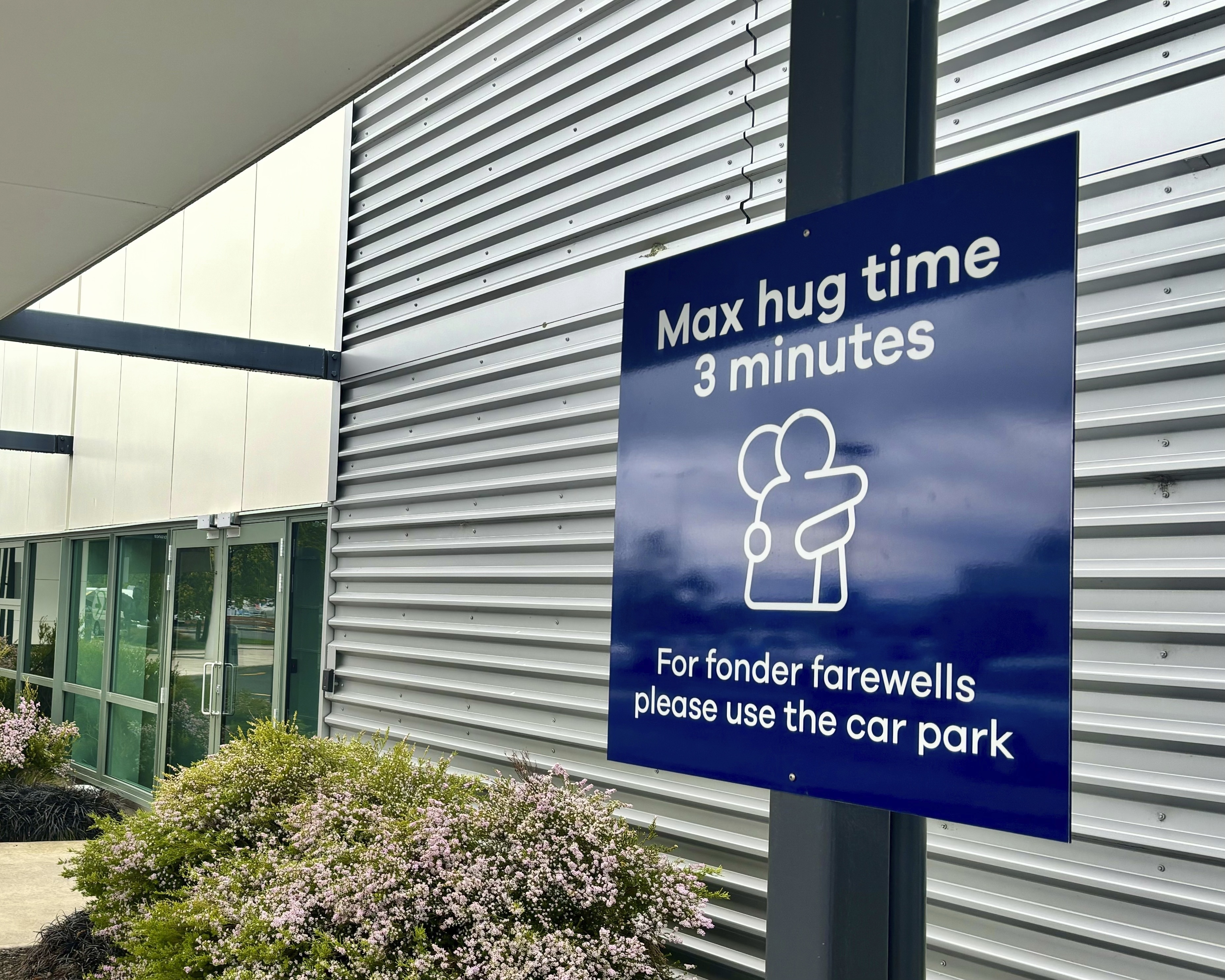 A sign informing time limits for visitors to the passenger drop-off area outside Dunedin Airport in Momona, New Zealand, Tuesday. Travelers wanting to embrace for longer can relocate to the parking lot. 