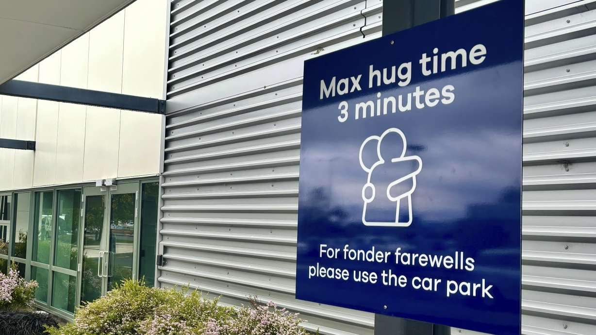 A sign informing time limits for visitors to the passenger drop-off area outside Dunedin Airport in Momona, New Zealand, Tuesday. Travelers wanting to embrace for longer can relocate to the parking lot.