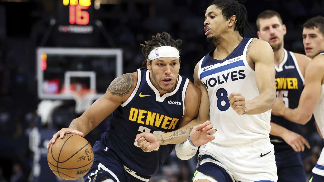 Denver Nuggets forward Aaron Gordon, left, drives past Minnesota Timberwolves forward Josh Minott (8) during the second half of a preseason NBA basketball game, Thursday, Oct. 17, 2024, in Minneapolis.