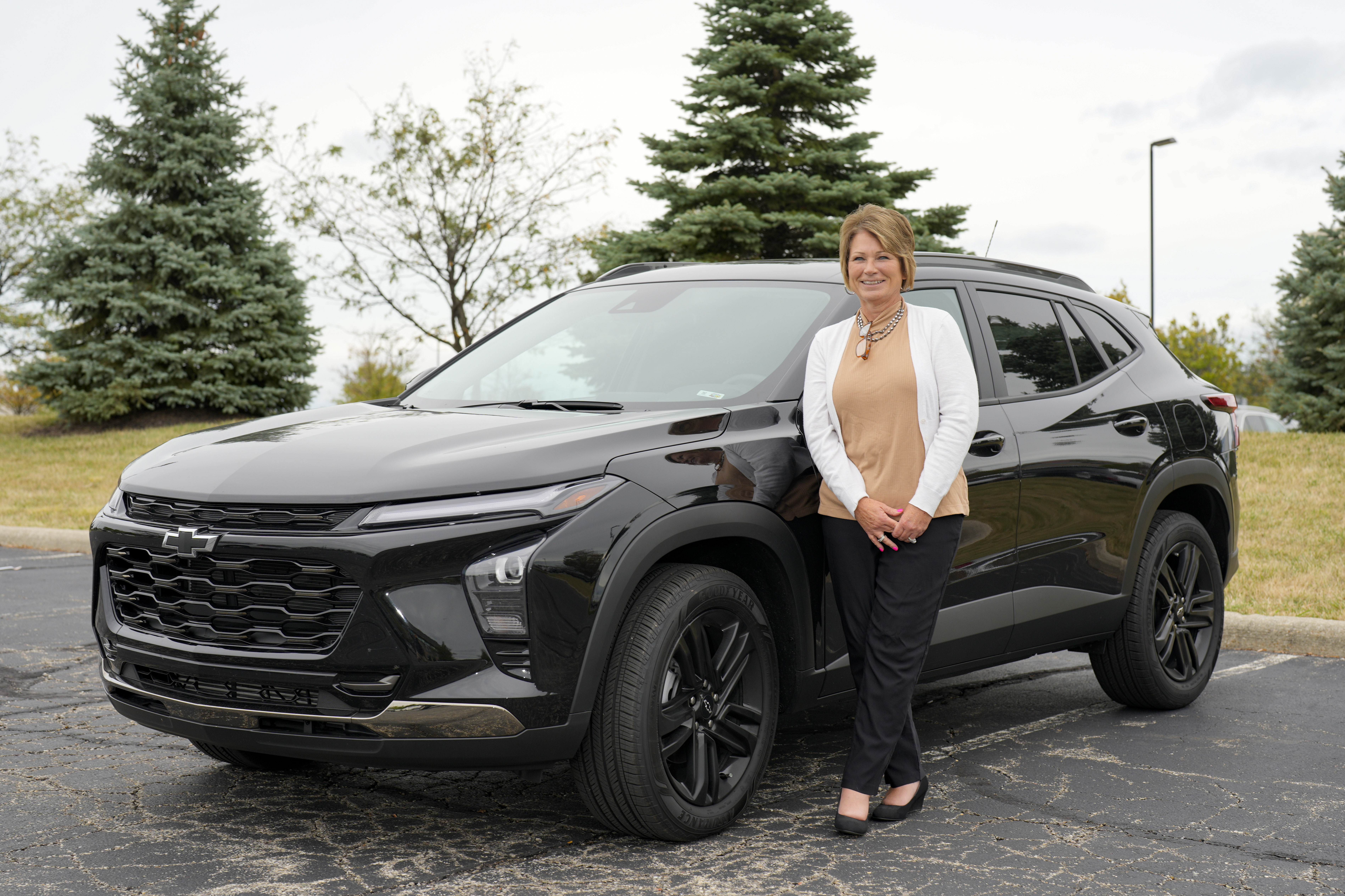 Michelle Chumley poses for a portrait beside her new Chevrolet Trax compact SUV, Sept. 26, in West Chester, Ohio. Across the industry, auto analysts say, an "affordability shift" is taking root.