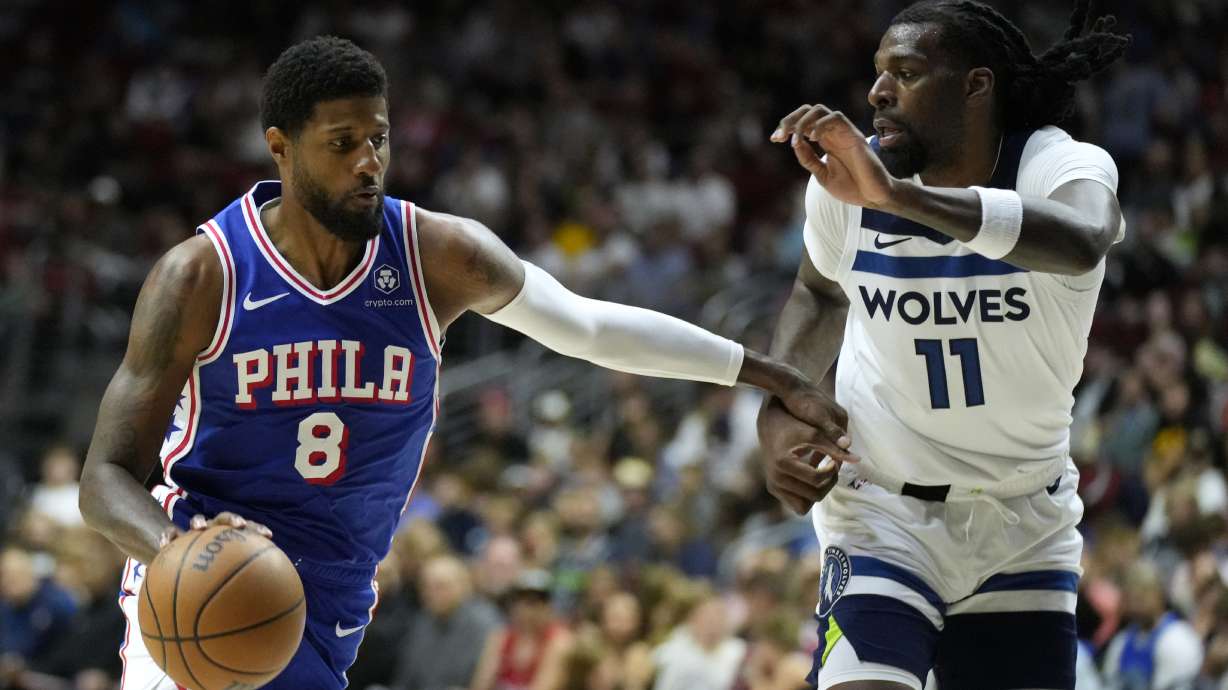 Philadelphia 76ers forward Paul George (8) drives to the basket past Minnesota Timberwolves center Naz Reid (11) during the first half of an NBA preseason basketball game, Friday, Oct. 11, 2024, in Des Moines, Iowa.