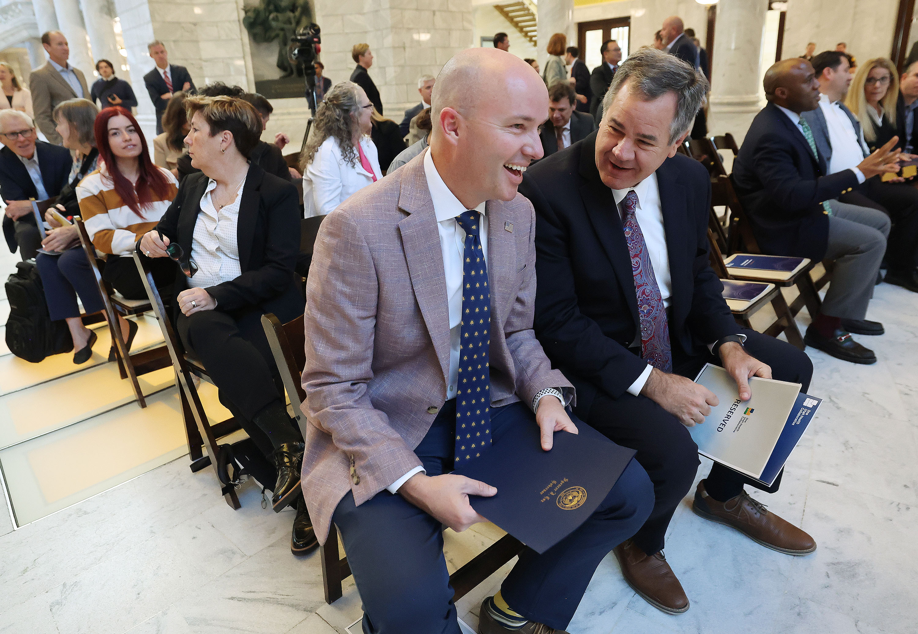 Gov. Spencer Cox talks with Jon Pike, Utah insurance commissioner, prior to a press conference to launch the Utah Model of Care at the Capitol rotunda in Salt Lake City on Tuesday.