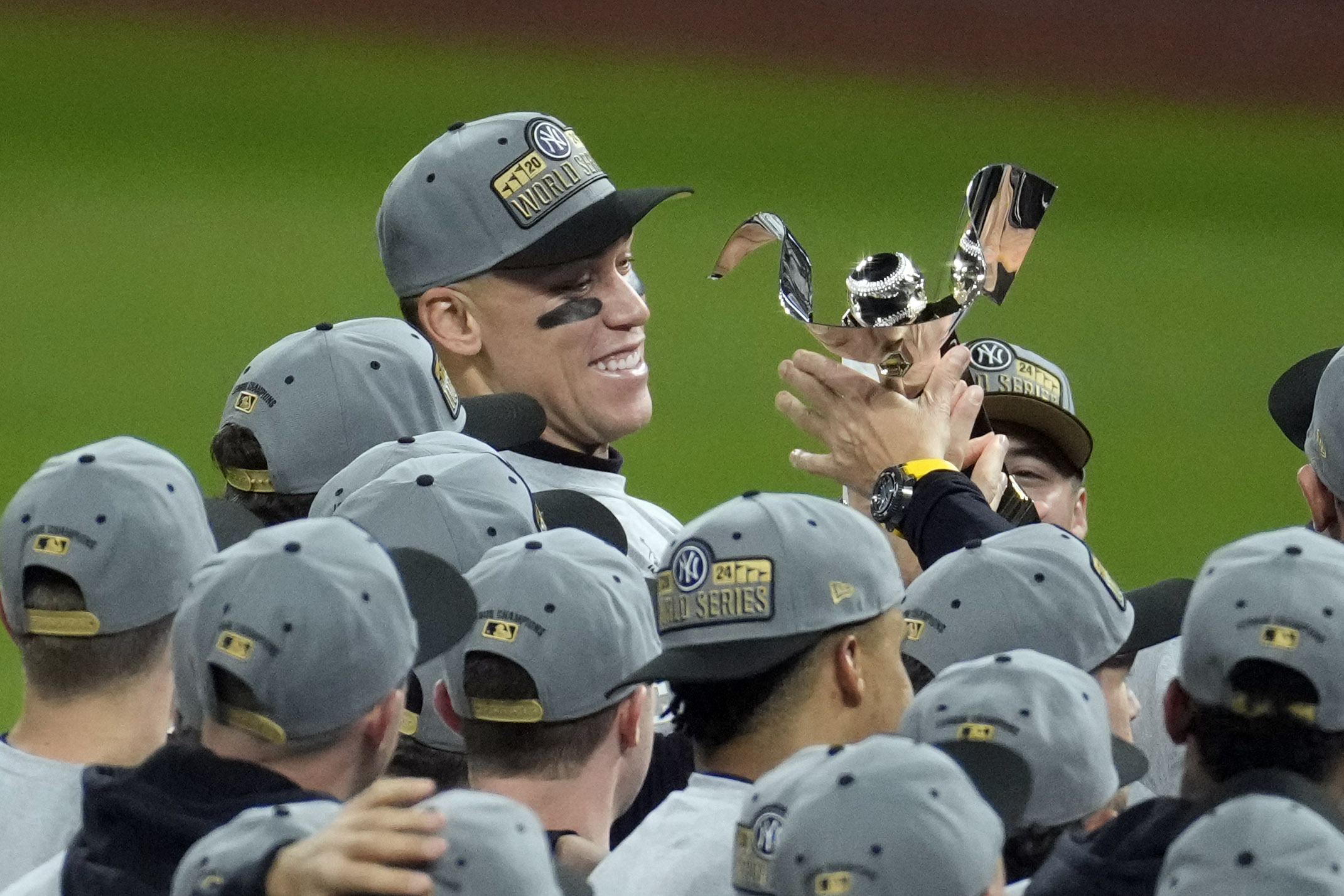 New York Yankees' Aaron Judge holds the American League Championship trophy after Game 5 of the baseball AL Championship Series against the Cleveland Guardians Sunday, Oct. 20, 2024, in Cleveland. The Yankees won 5-2 to advance to the World Series.