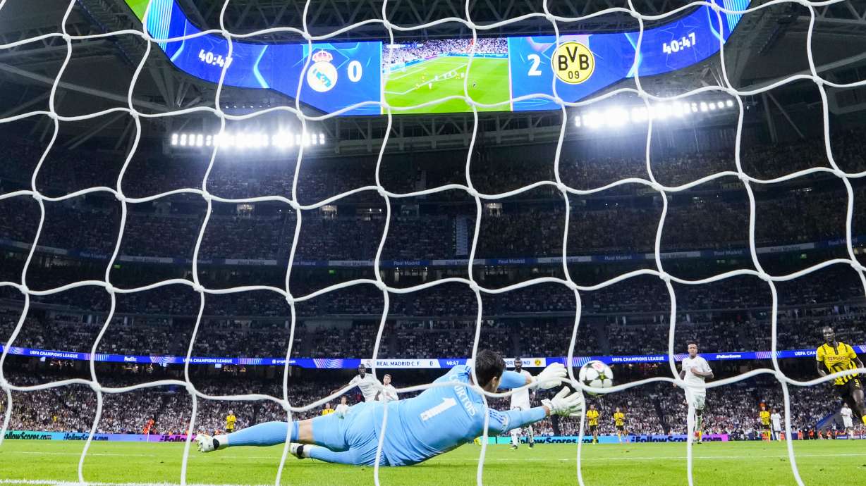 Real Madrid's goalkeeper Thibaut Courtois blocks a shoot during the Champions League opening phase soccer match between Real Madrid and Borussia Dortmund at the Santiago Bernabeu stadium in Madrid, Tuesday, Oct. 22, 2024.