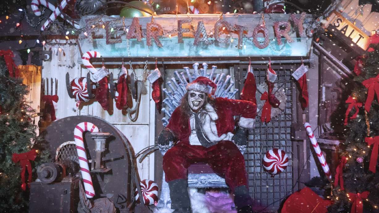 Caretaker Karl, a mascot of Fear Factory, poses for a photo in a Santa suit in the haunted house's Christmas Town section. The Salt Lake business will debut the feature over the next two weekends.