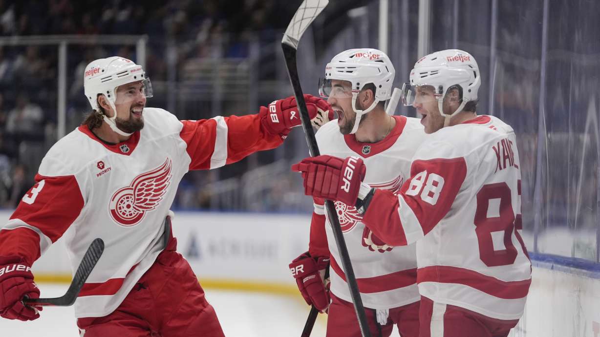 Detroit Red Wings' Patrick Kane (88) celebrates with Erik Gustafsso and Justin Holl (3) after scoring a goal during the first period of an NHL hockey game against the New York Islanders, Tuesday, Oct. 22, 2024, in Elmont, N.Y.