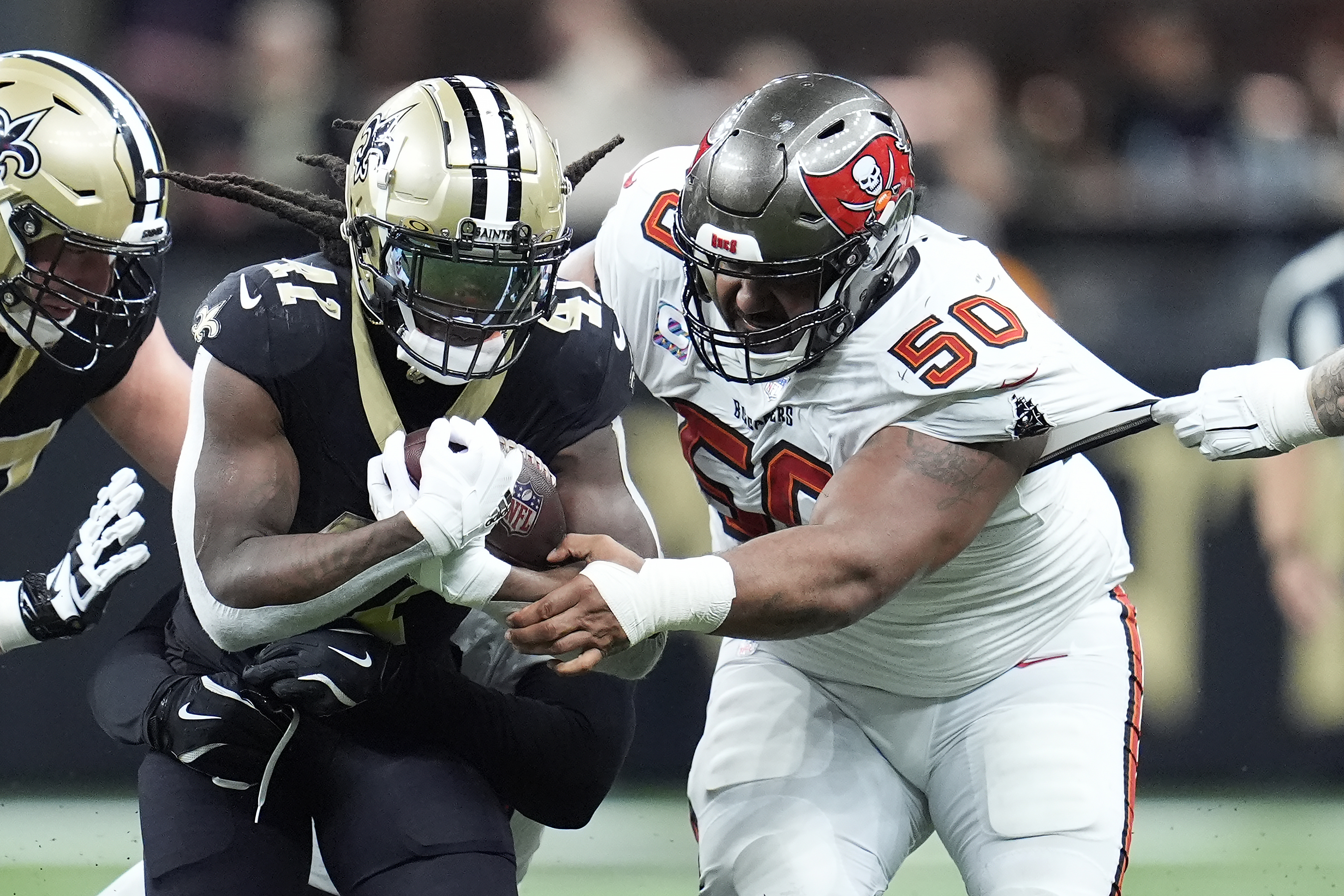 New Orleans Saints running back Alvin Kamara, left, runs against Tampa Bay Buccaneers defensive tackle Vita Vea (50) during the first half of an NFL football game in New Orleans, Sunday, Oct. 13, 2024.