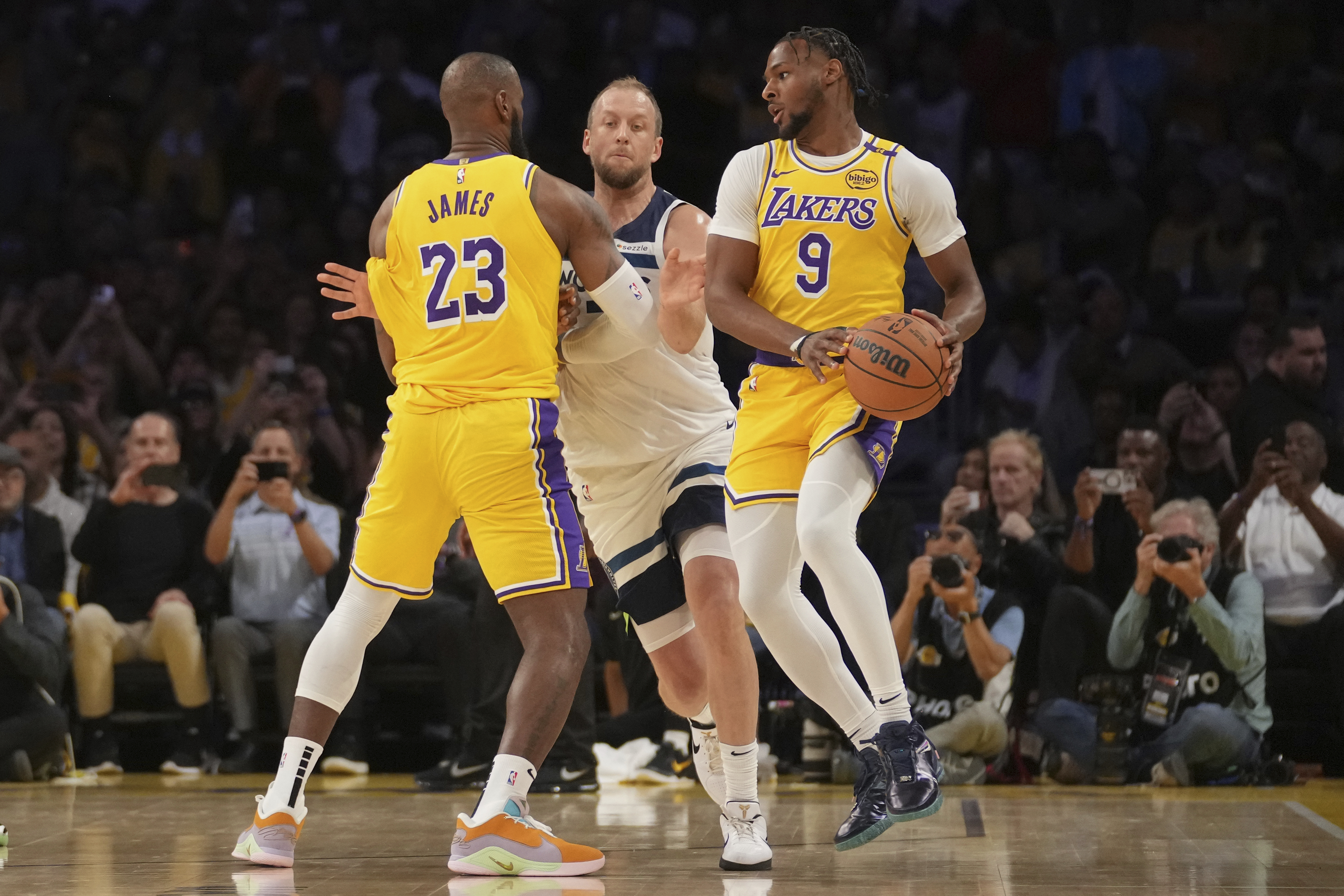 Los Angeles Lakers guard Bronny James (9) handles the ball during the first half of an NBA basketball game against the Minnesota Timberwolves, Tuesday, Oct. 22, 2024, in Los Angeles.
