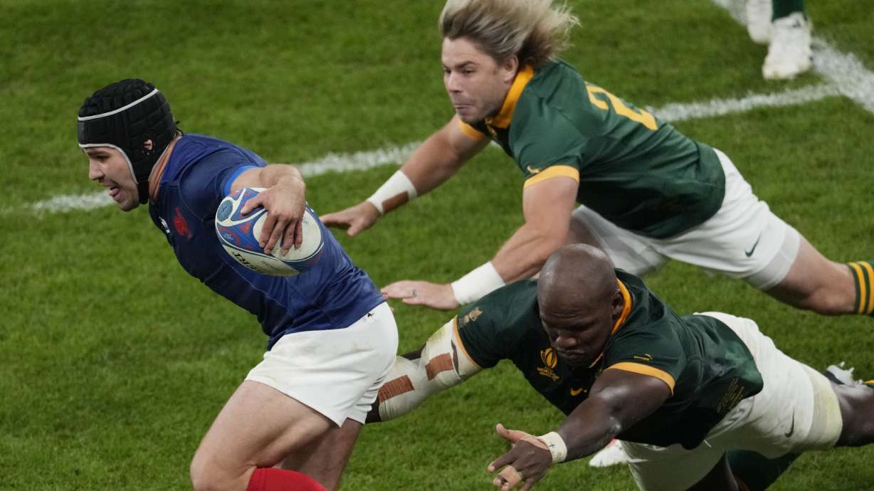 FILE - France's Antoine Dupont, left, challenges for the ball during the Rugby World Cup quarterfinal match between France and South Africa at the Stade de France in Saint-Denis, near Paris, Sunday, Oct. 15, 2023.