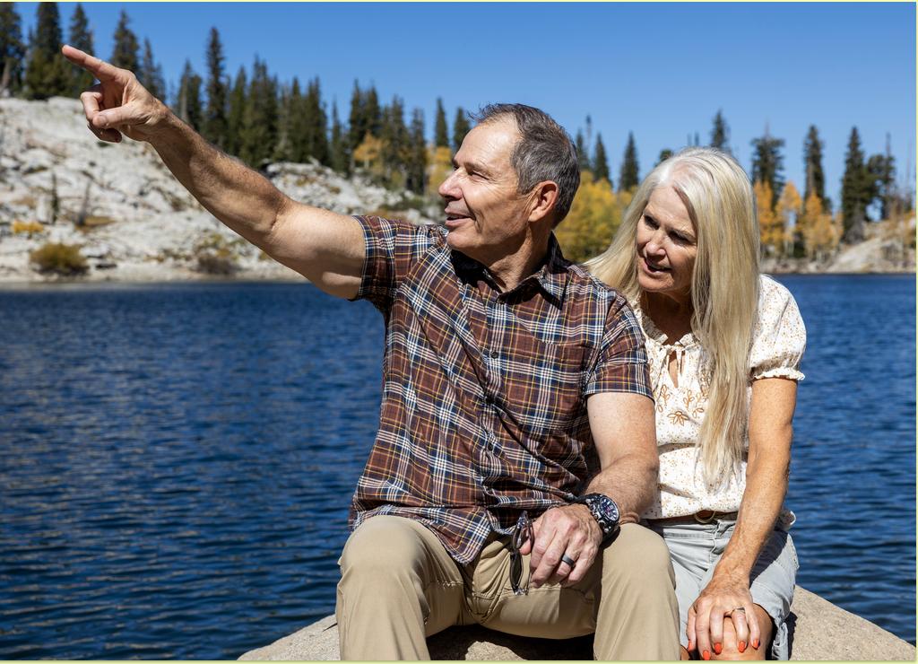 Rep. John Curtis sits with his wife, Sue, on a rock and points to other trails on Lake Mary Trail in Brighton on Sept. 28.