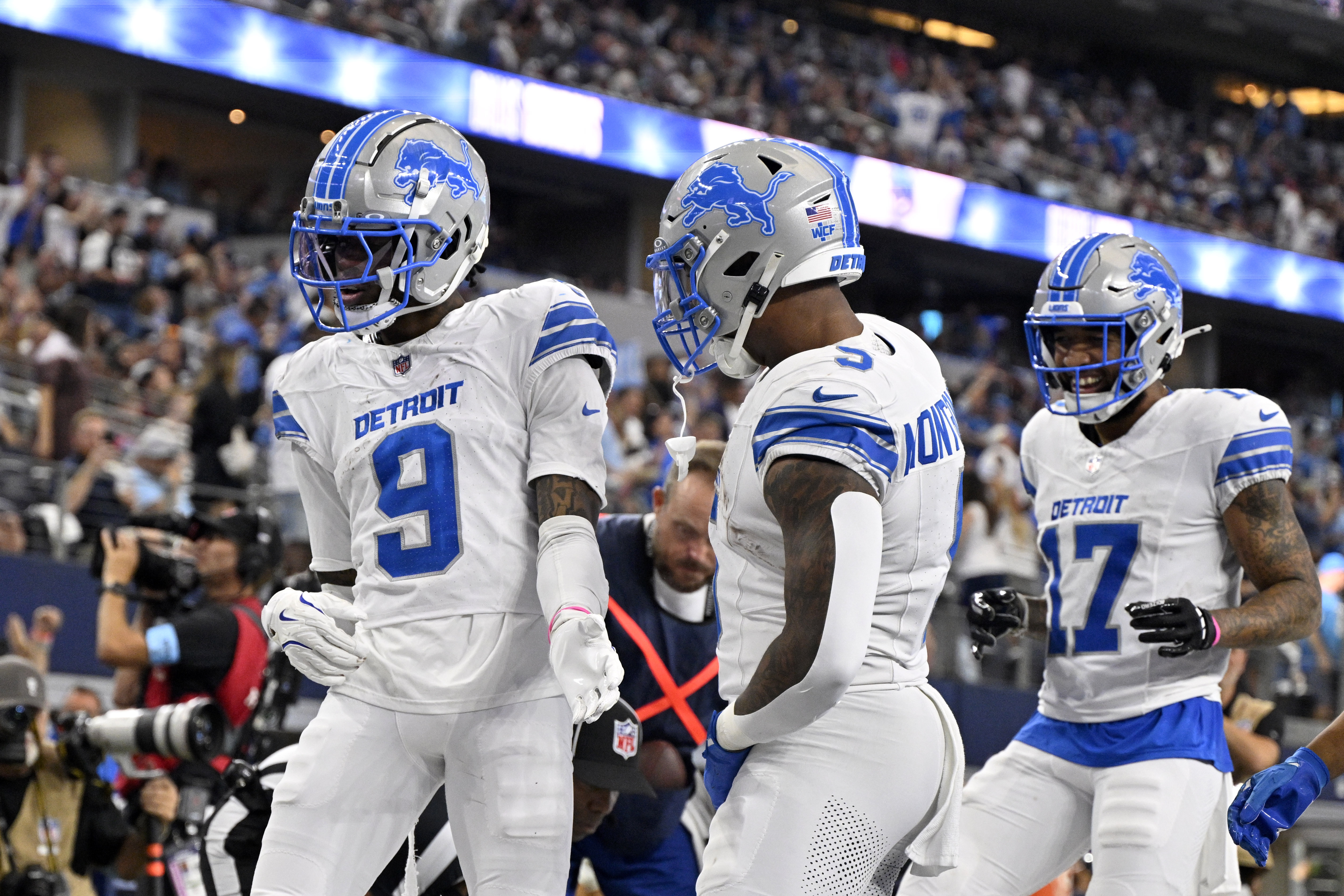 Detroit Lions' Jameson Williams (9), David Montgomery (5) and Tim Patrick (17) celebrate after Williams caught a touchdown pass in the second half of an NFL football game against the Dallas Cowboys in Arlington, Texas, Sunday, Oct. 13, 2024. 