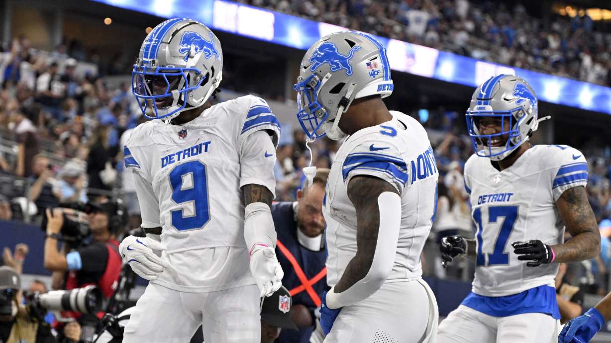 Detroit Lions' Jameson Williams (9), David Montgomery (5) and Tim Patrick (17) celebrate after Williams caught a touchdown pass in the second half of an NFL football game against the Dallas Cowboys in Arlington, Texas, Sunday, Oct. 13, 2024.