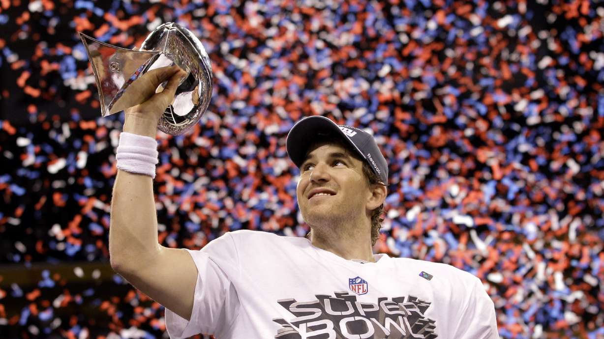 FILE - New York Giants quarterback Eli Manning holds up the Vince Lombardi Trophy while celebrating his team's 21-17 win over the New England Patriots in the NFL Super Bowl XLVI football game, Feb. 5, 2012, in Indianapolis.