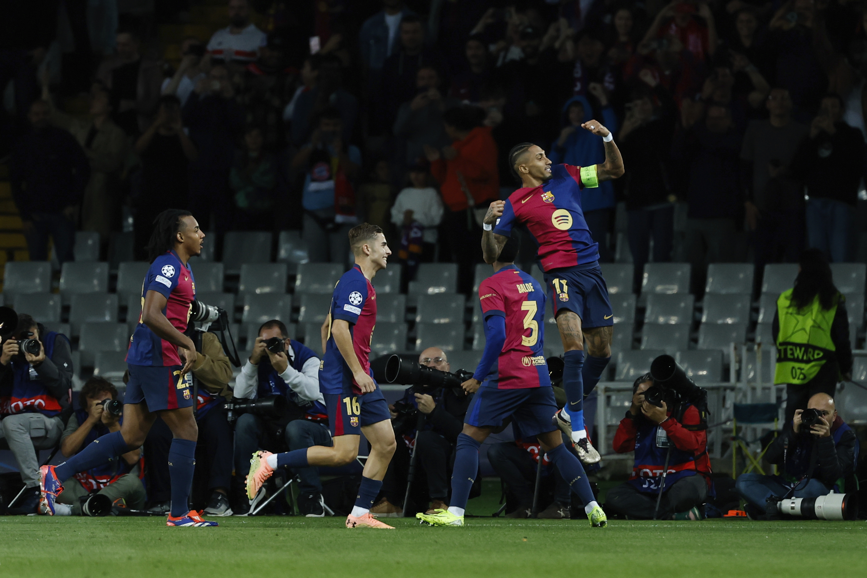 Barcelona's Raphinha , right, celebrates with teammates after scoring the opening goal during a Champions League opening phase soccer match between Barcelona and Bayern Munich at the Lluis Companys Olympic Stadium in Barcelona, Spain, Wednesday, Oct. 23, 2024.