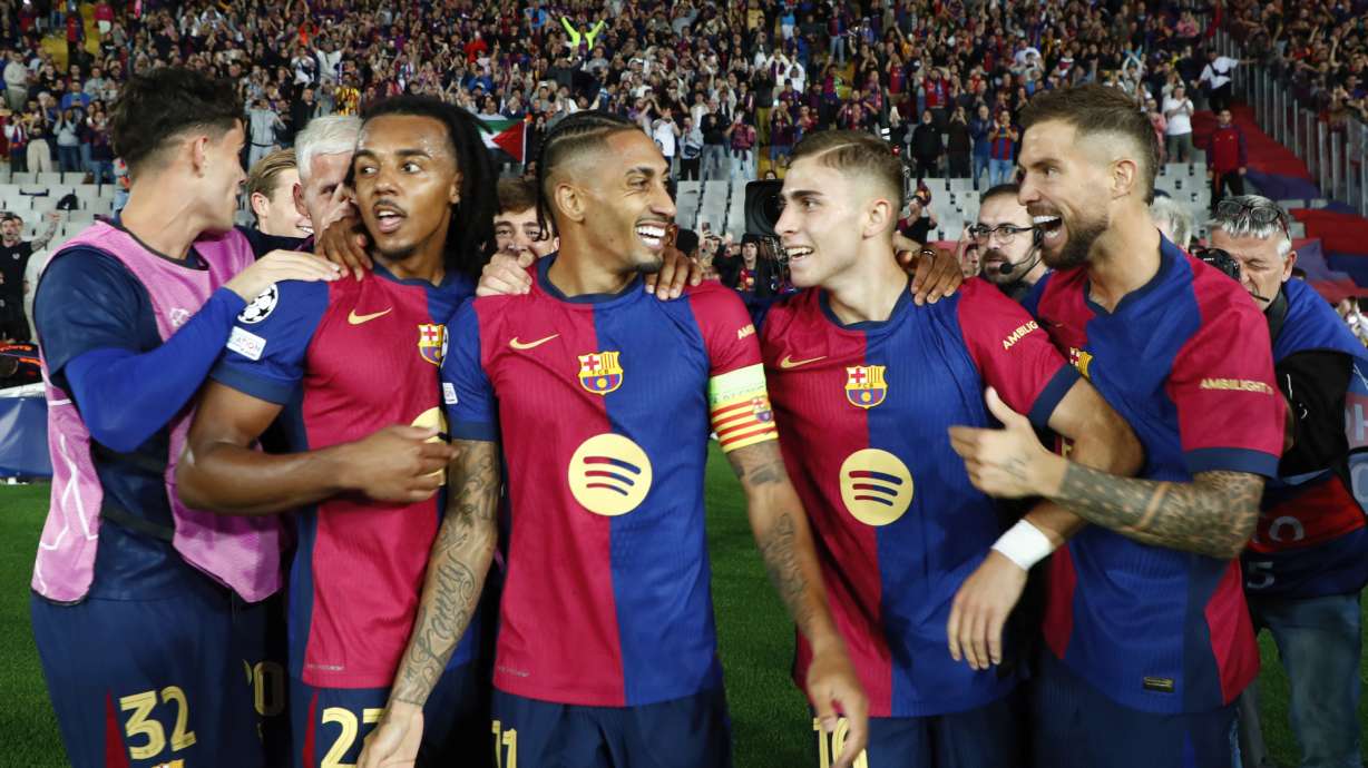 Barcelona's Raphinha, centre, celebrates with teammates after scoring his sides forth goal during a Champions League opening phase soccer match between Barcelona and Bayern Munich at the Lluis Companys Olympic Stadium in Barcelona, Spain, Wednesday, Oct. 23, 2024.