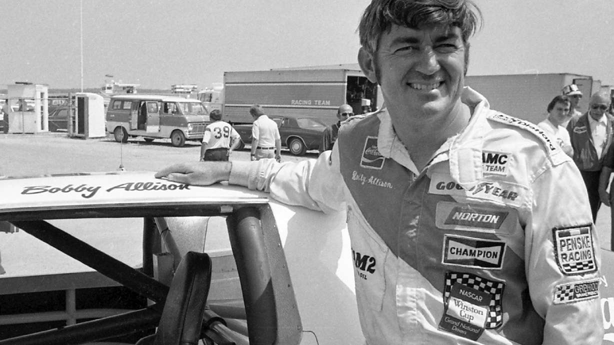 FILE - Bobby Allison stands beside his car and talks with the press after winning the pole position during qualifyiing for the 500 mile grand national stock car race at Pocono Raceway, Aug. 2, 1975, in Long Pond, Pa.