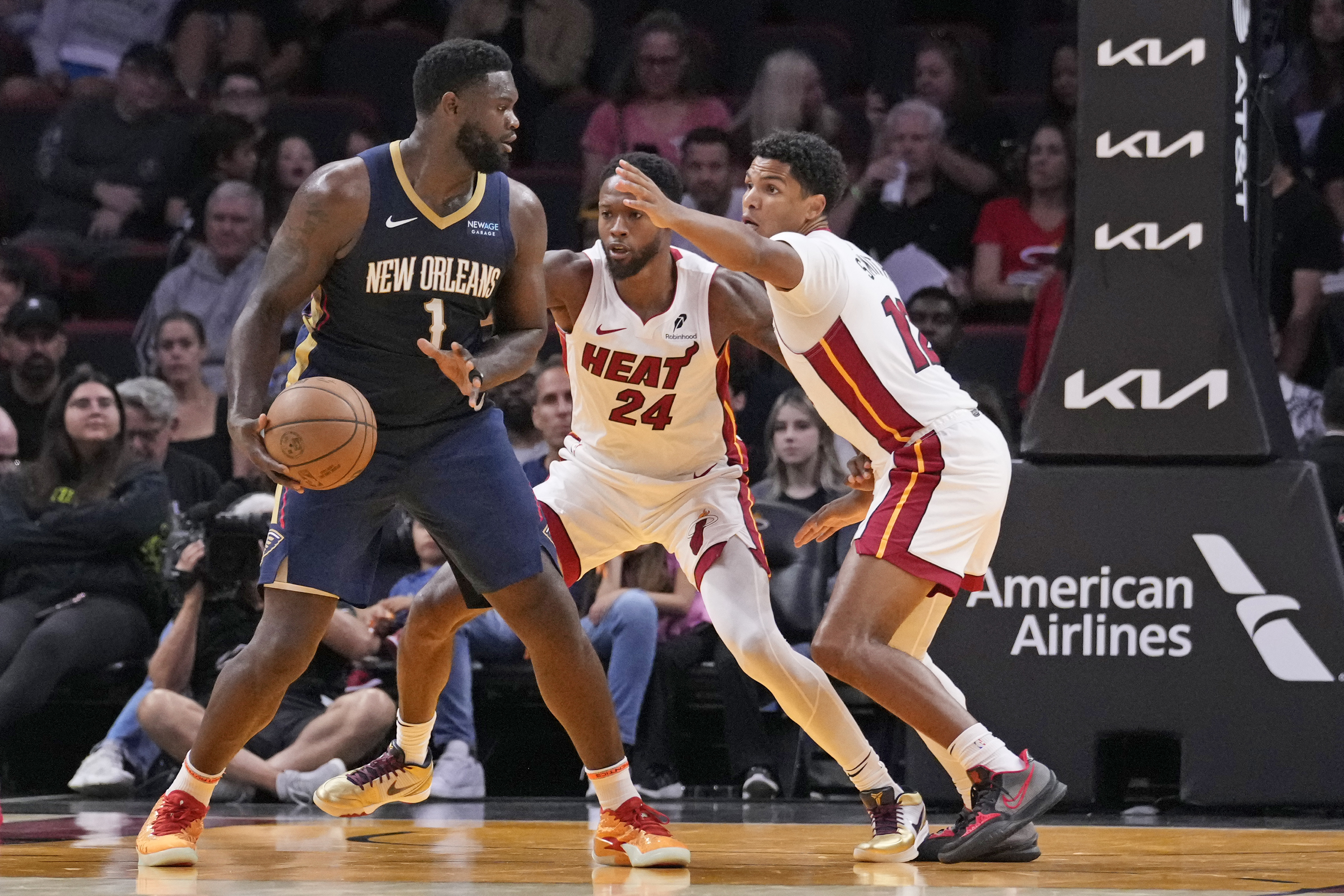 New Orleans Pelicans forward Zion Williamson (1) looks for an opening past Miami Heat forward Haywood Highsmith (24) and guard Dru Smith (12) during the first half of an NBA preseason basketball game, Sunday, Oct. 13, 2024, in Miami. 
