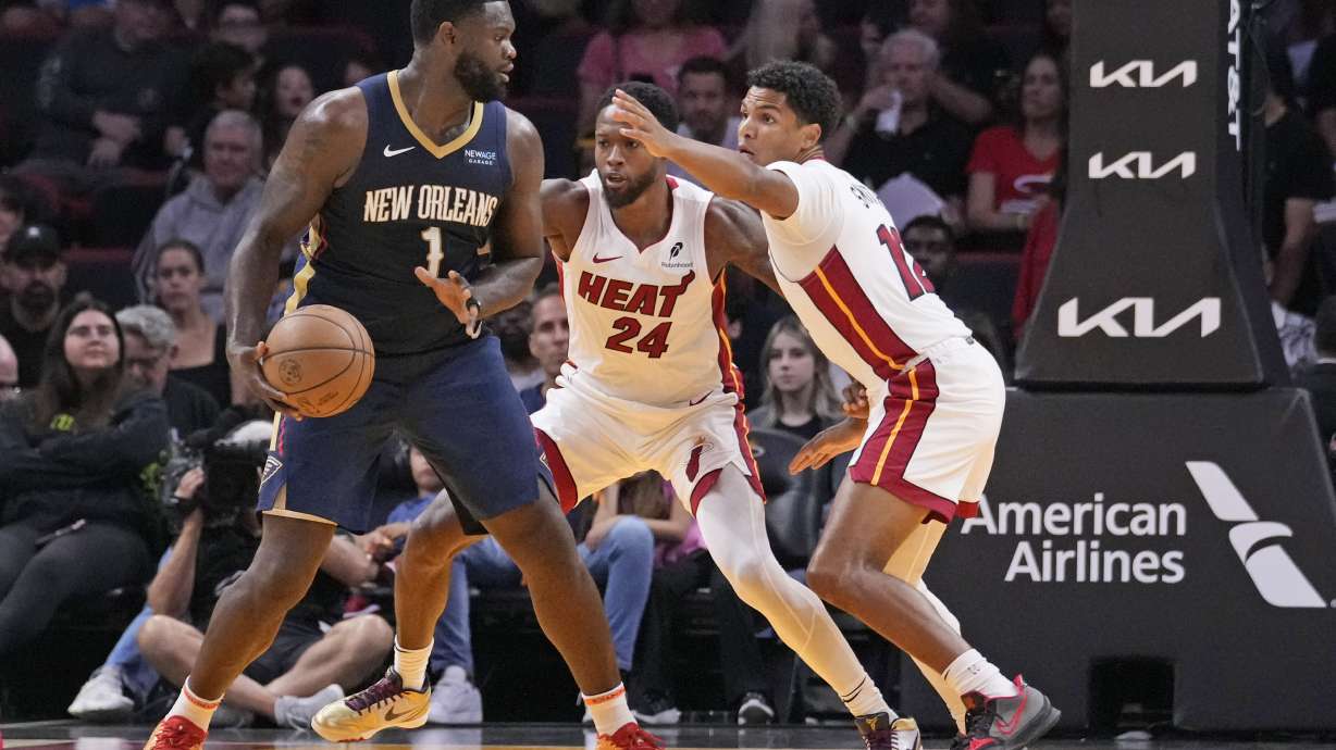 New Orleans Pelicans forward Zion Williamson (1) looks for an opening past Miami Heat forward Haywood Highsmith (24) and guard Dru Smith (12) during the first half of an NBA preseason basketball game, Sunday, Oct. 13, 2024, in Miami.