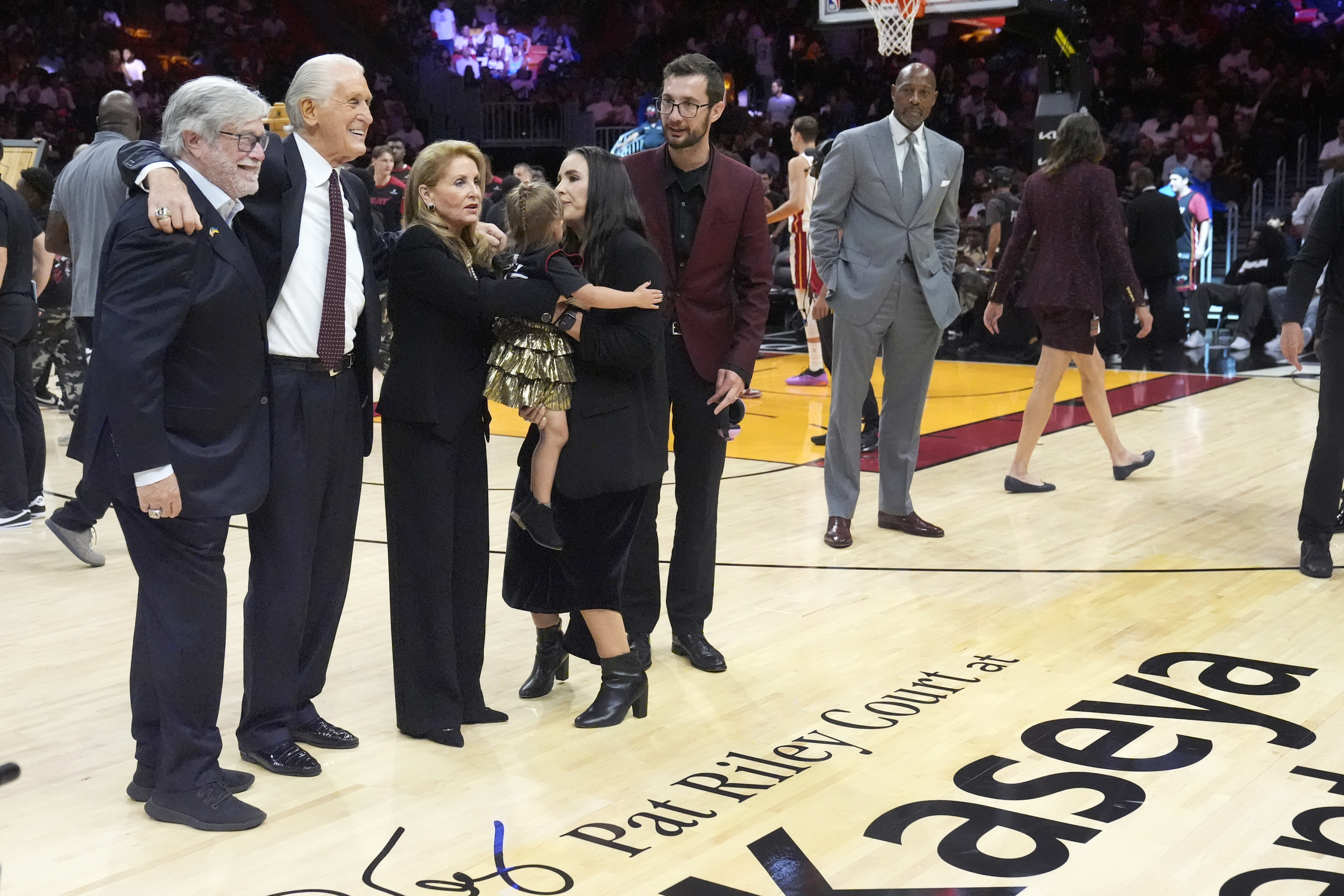 Miami Heat managing general partner Micky Arison, left, poses with Heat president Pat Riley, second from left, and his family after celebrating Rily's 30th season with the franchise, the Heat unveiled Pat Riley Court during a halftime ceremony of an NBA basketball game between the Heat and the Orlando Magic, Wednesday, Oct. 23, 2024, in Miami. 