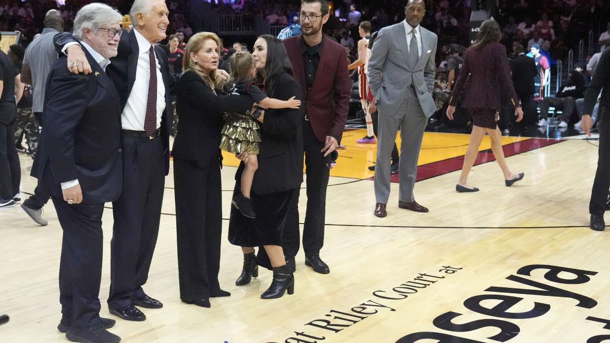 Miami Heat managing general partner Micky Arison, left, poses with Heat president Pat Riley, second from left, and his family after celebrating Rily's 30th season with the franchise, the Heat unveiled Pat Riley Court during a halftime ceremony of an NBA basketball game between the Heat and the Orlando Magic, Wednesday, Oct. 23, 2024, in Miami.