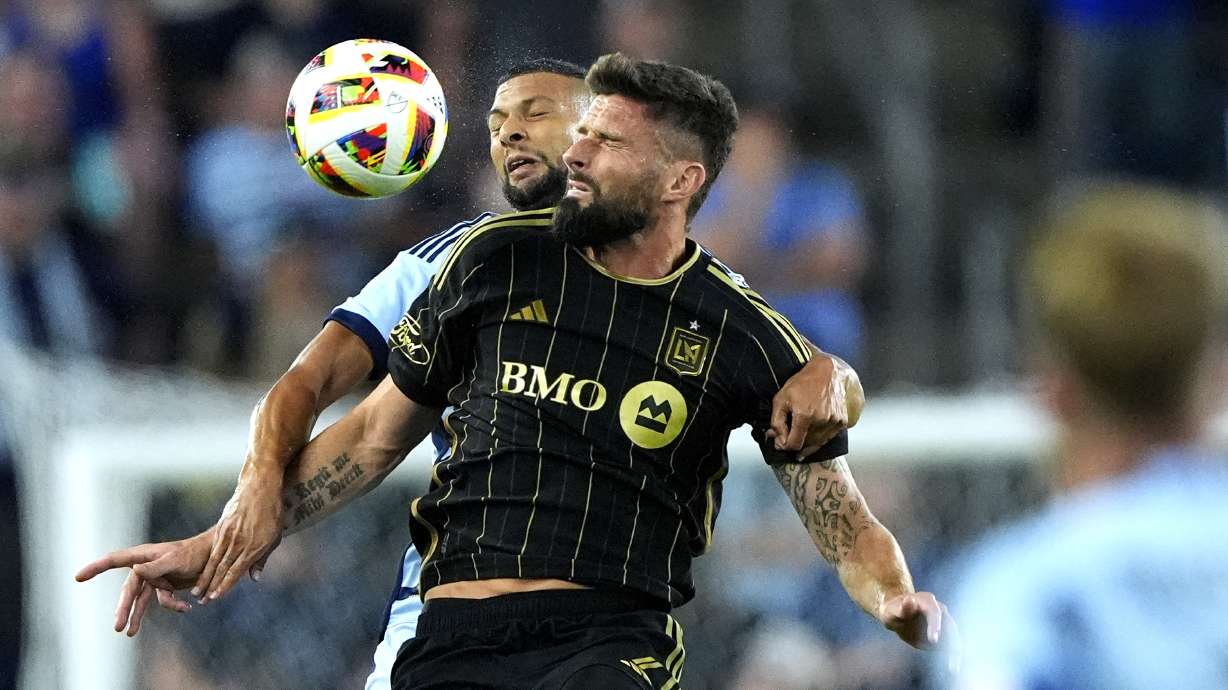 Sporting Kansas City defender Joaquin Fernandez, back, and Los Angeles FC attacker Olivier Giroud battle for the ball during the first half of an MLS soccer match Saturday, Oct. 5, 2024, in Kansas City, Kan.