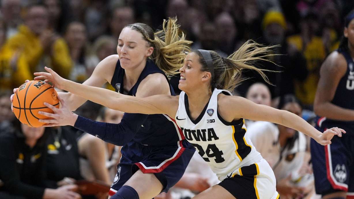 FILE -UConn guard Paige Bueckers, left, fights for a loose ball with Iowa guard Gabbie Marshall (24) during the first half of a Final Four college basketball game in the women's NCAA Tournament, Friday, April 5, 2024, in Cleveland.