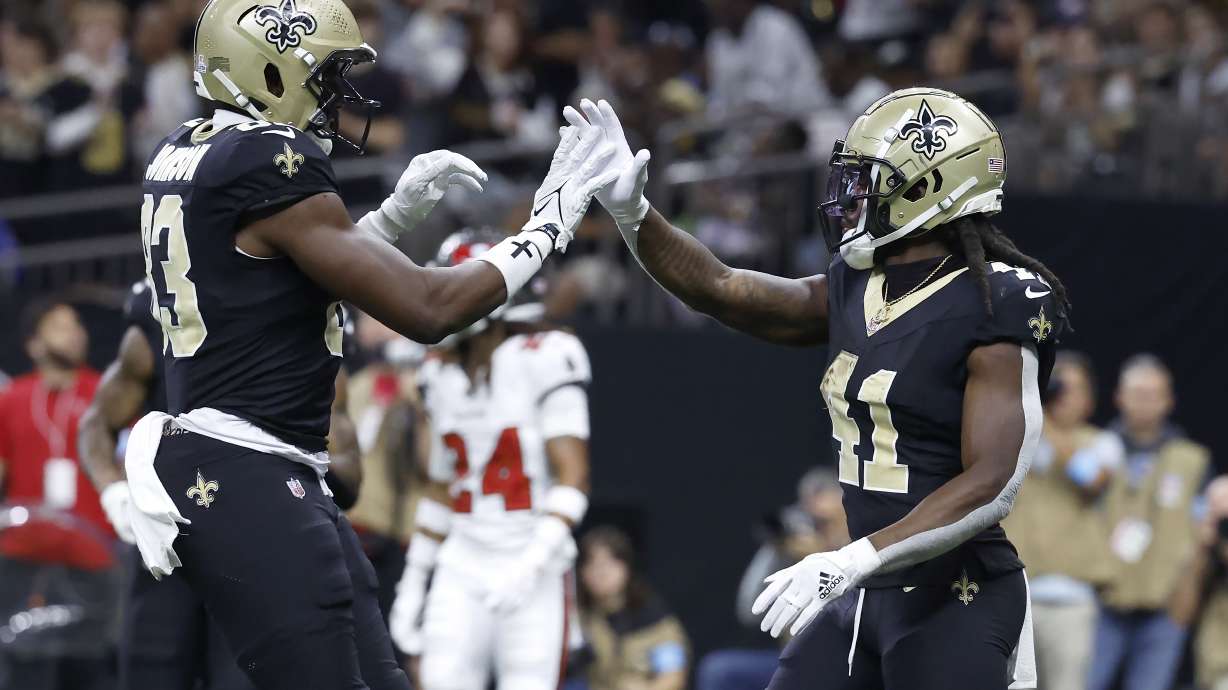 New Orleans Saints running back Alvin Kamara, right, is congratulated by tight end Juwan Johnson after scoring against the Tampa Bay Buccaneers during the first half of an NFL football game in New Orleans, Sunday, Oct. 13, 2024.