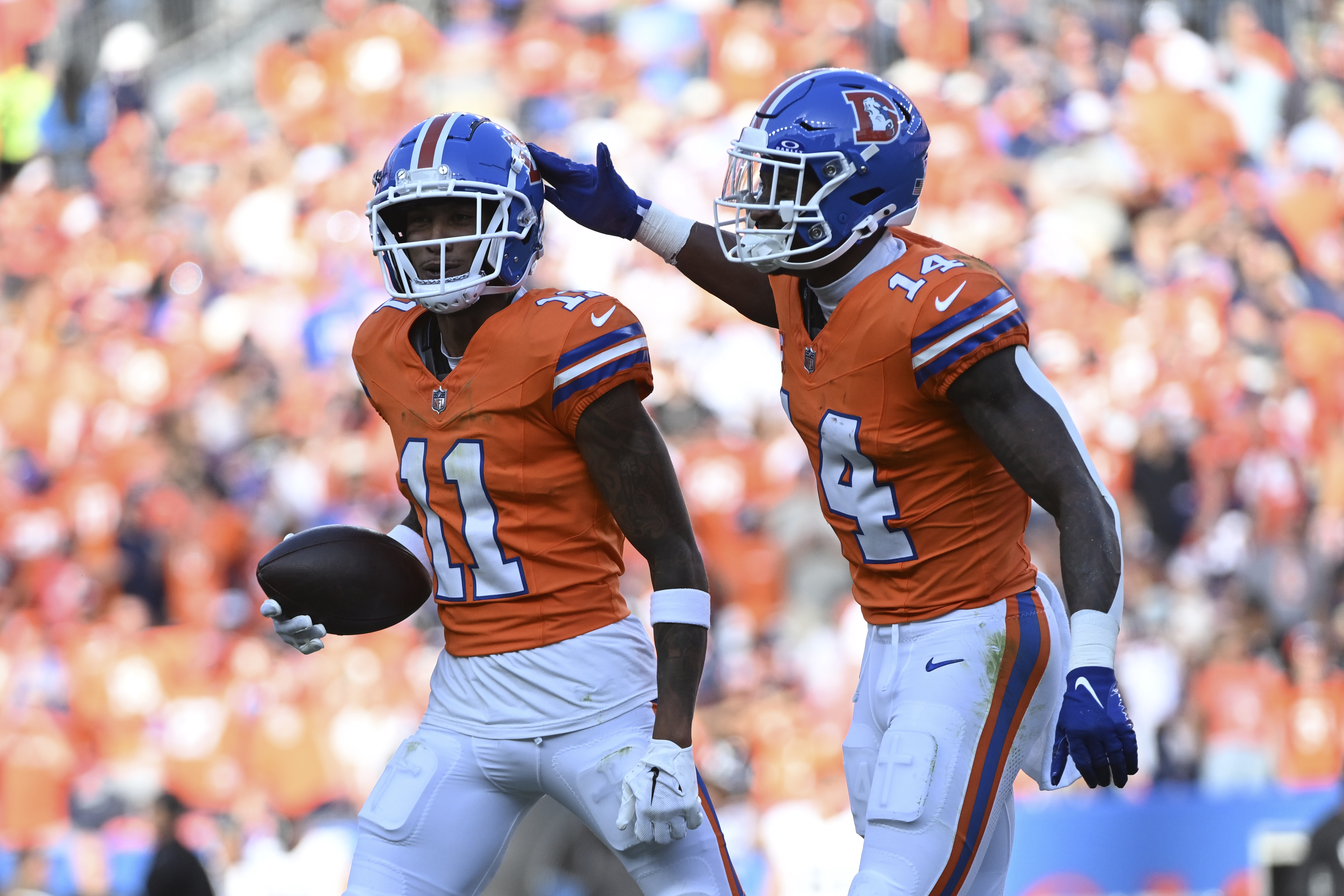 Denver Broncos wide receiver Josh Reynolds (11) celebrates his 9-yard reception for a touchdown with teammate wide receiver Courtland Sutton (14) during the second half of an NFL football game against the Las Vegas Raiders, Sunday, Oct. 6, 2024, in Denver.