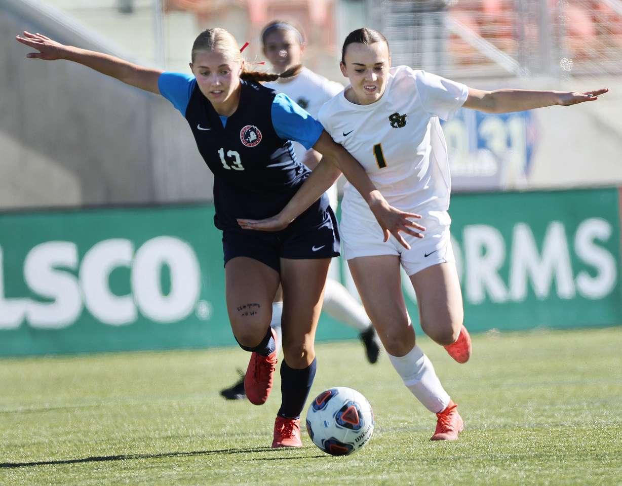 American Heritage’s Bree Harmon (13) competes with St. Joseph’s Preslie Thiel (1) during 2A semifinals soccer at Zions Bank Stadium in Herriman on Thursday, Oct. 24, 2024.