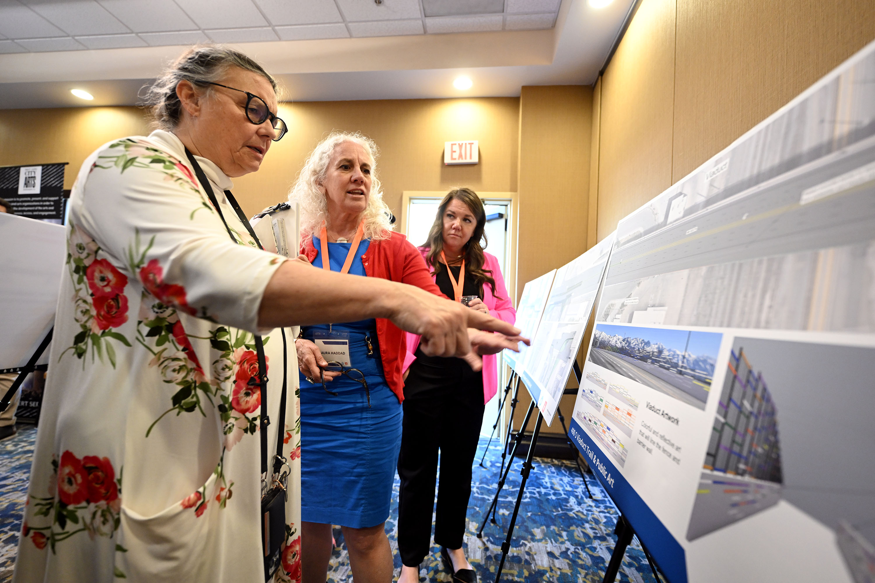 Julie Olson looks over the displays for a new multiuse 400 South trail in Salt Lake City with Laura Haddad and Katie Williams. Olson is hoping that local artists can be included in the project.