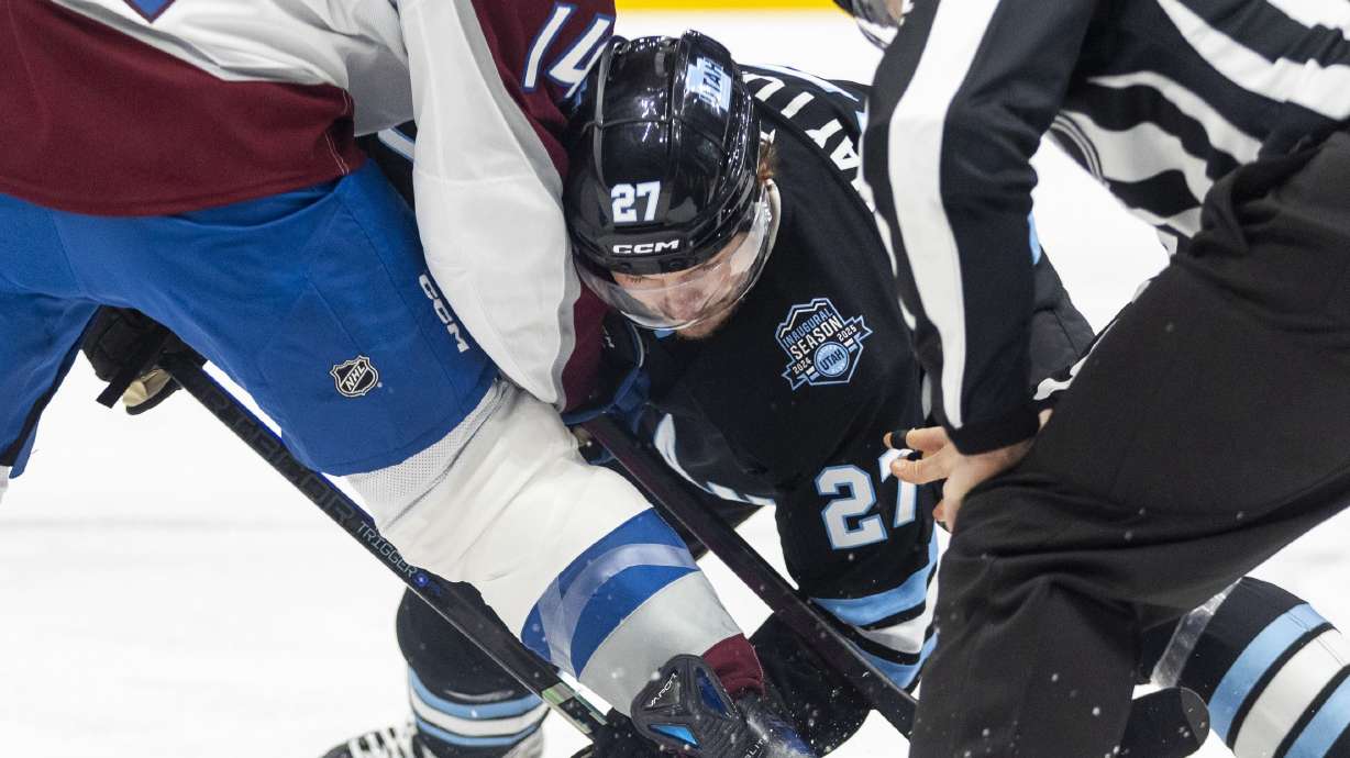 Utah Hockey Club center Barrett Hayton (27) and Colorado Avalanche right wing Chris Wagner (14) battle for the puck during a game at the Delta Center in Salt Lake City on Thursday, Oct. 24, 2024.