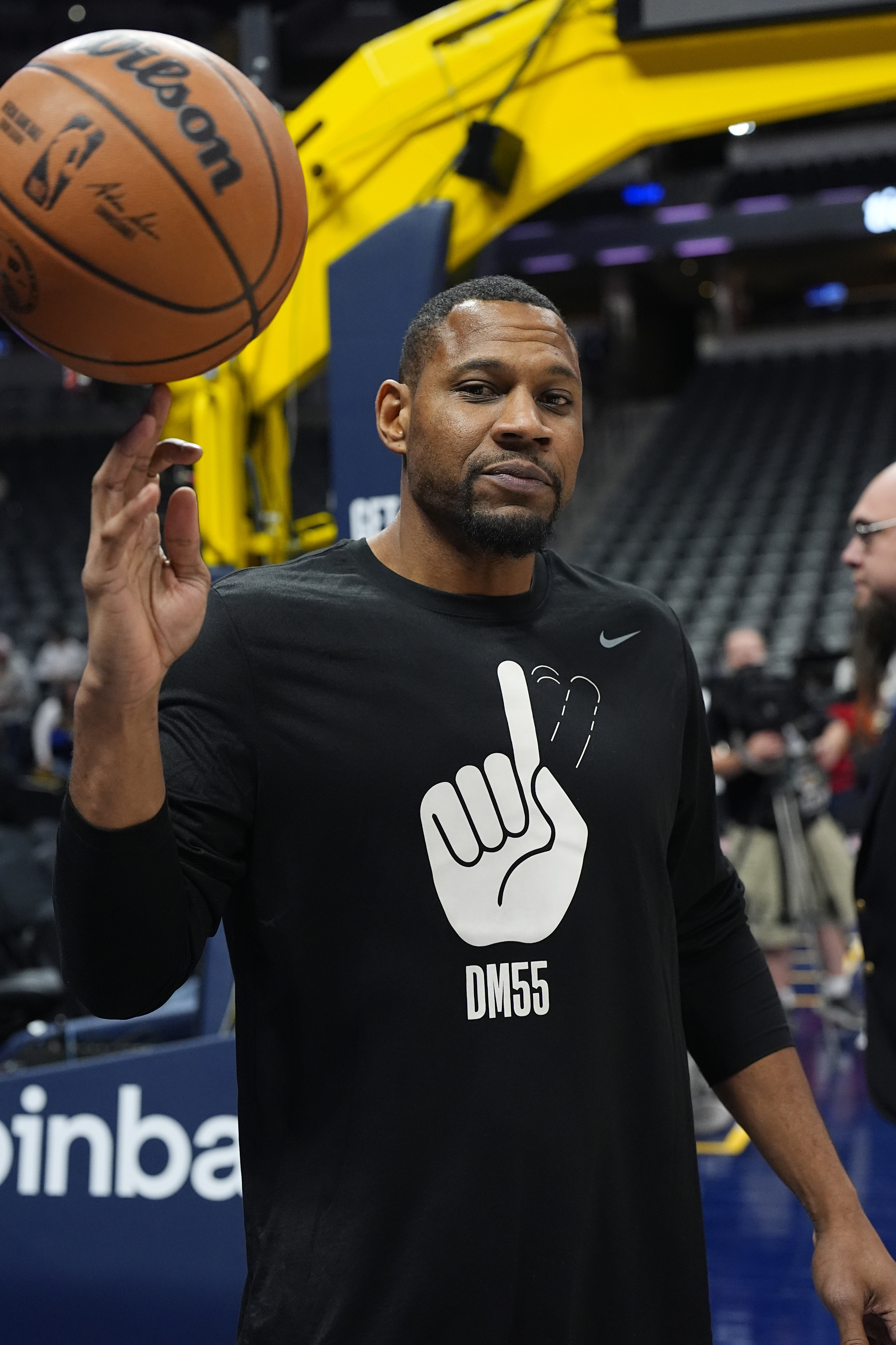 Denver Nuggets development coach Stephen Graham wears a shirt in honor of former Nuggets center Dikemba Mutombo who died last month as players warm up before an NBA basketball game against the Oklahoma City Thunder Thursday, Oct. 24, 2024 in Denver. 