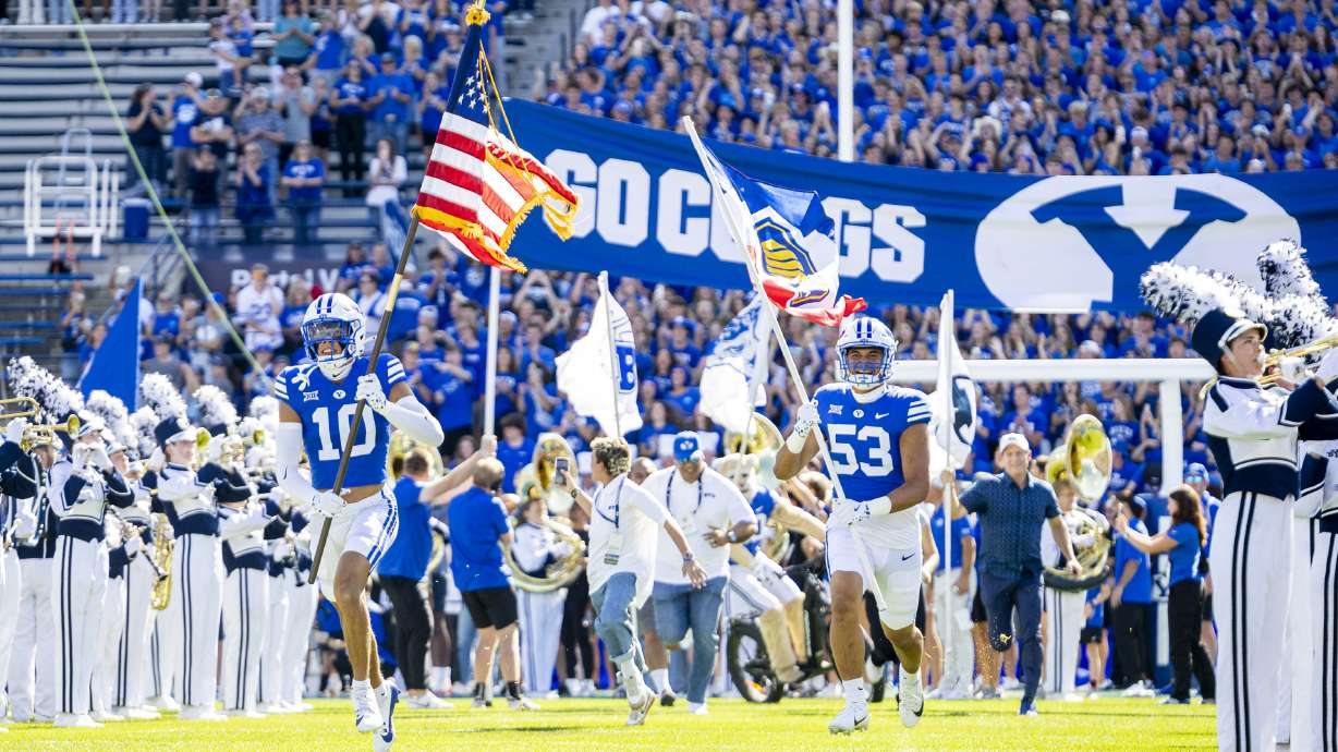 BYU safety Faletau Satuala (10) and defensive end Orion Maile-Kaufusi (53) make their entrance with the rest of the team before a game against the Arizona Wildcats held at LaVell Edwards Stadium in Provo on Saturday, Oct. 12, 2024.