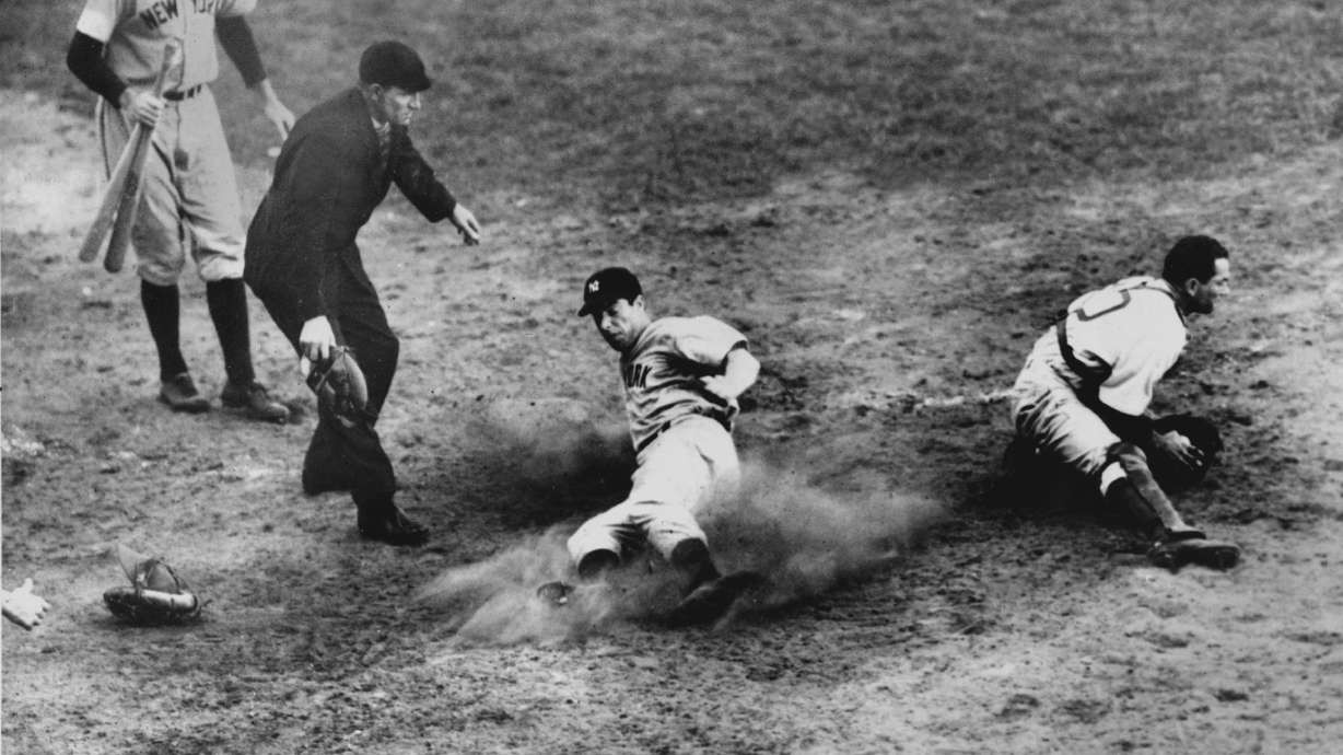 FILE - New York Yankees outfielder Joe DiMaggio (5) slides home safely in the ninth inning to score his team's fifth and winning run in Game 4 of the World Series against the Brooklyn Dodgers at Ebbets Field, Brooklyn, N.Y., Oct. 5, 1941. Dodgers catcher Mickey Owen has the ball. The Yankees won 7 to 4.