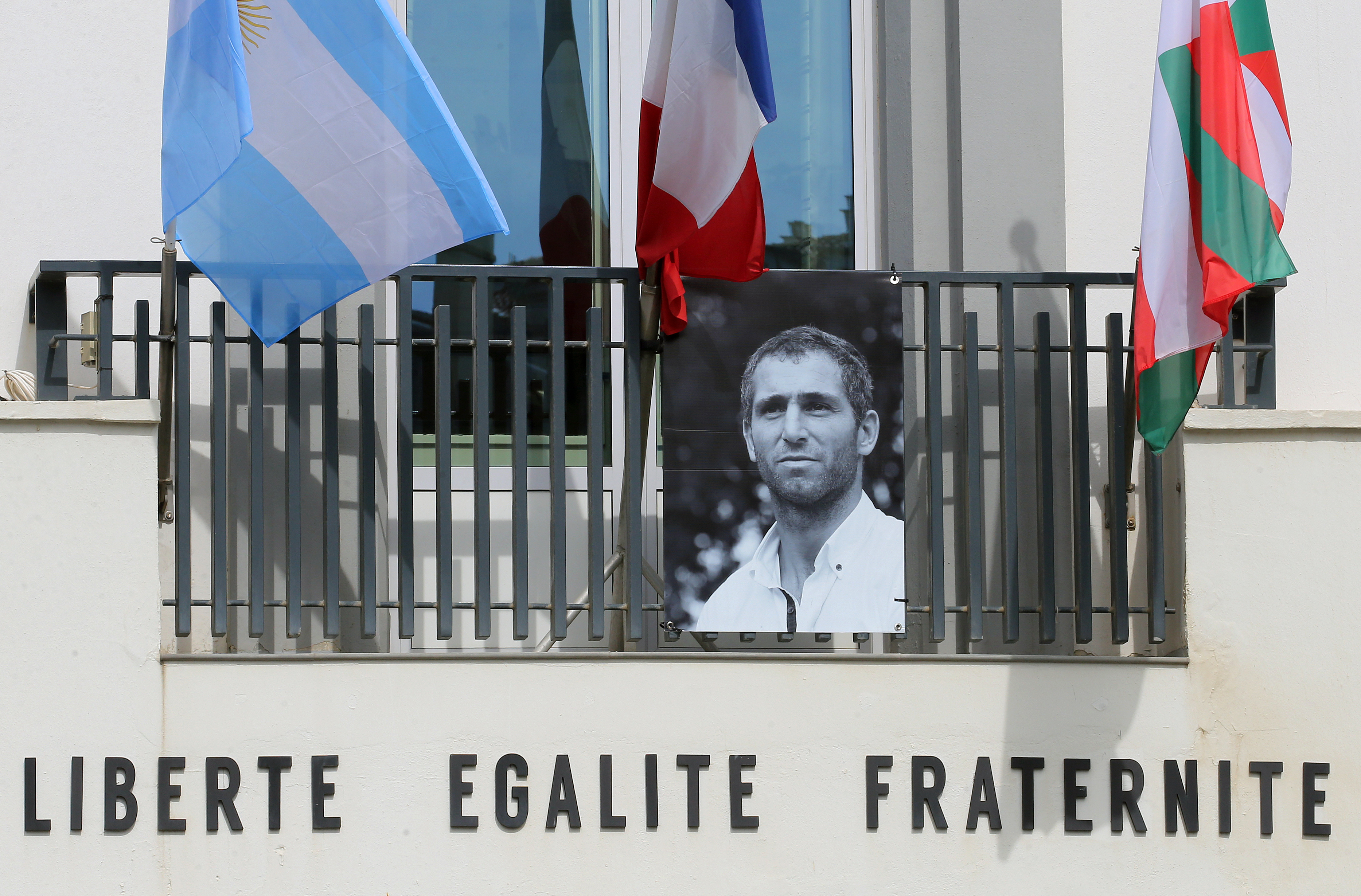 FILE - A portrait of Federico Martin Aramburu is seen under Argentinian, French and Basque flags hanging on the balcony of the town hall in Biarritz, France, March 25, 2022. 
