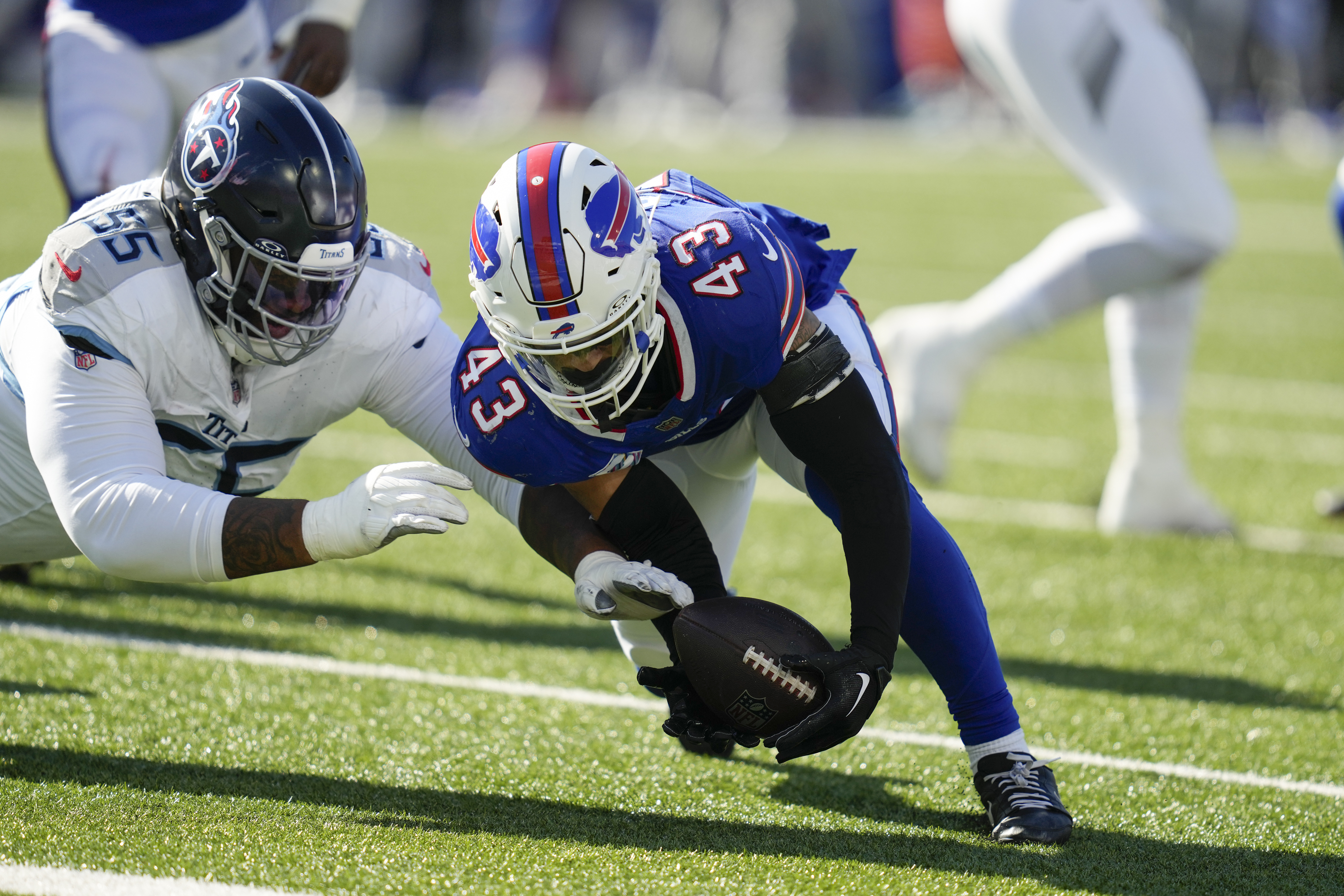 Tennessee Titans offensive tackle JC Latham (55) and Buffalo Bills linebacker Terrel Bernard (43) dive for a loose ball during the first half of an NFL football game Sunday, Oct. 20, 2024, in Orchard Park, N.Y.
