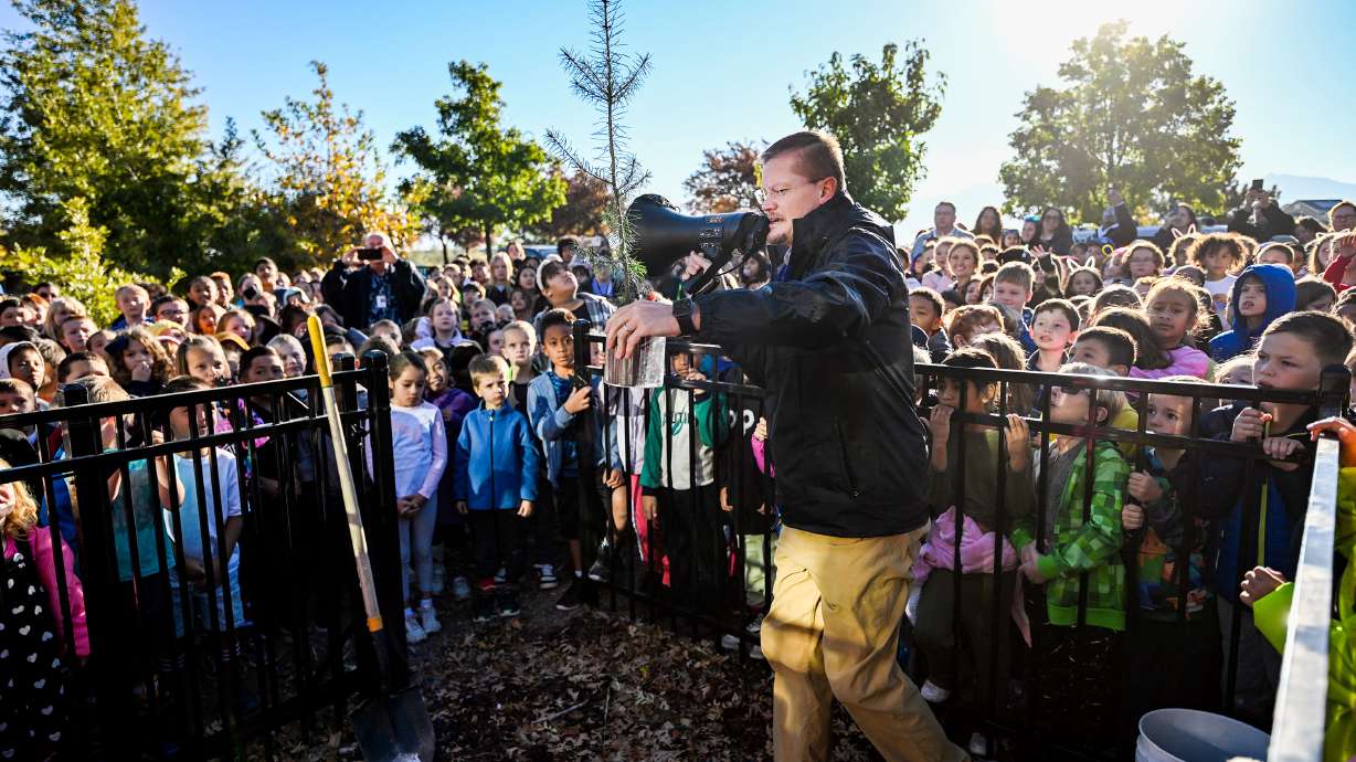 John Paul Sorensen, principal of Neil Armstrong Academy, holds a moon tree sapling up for all the students and teachers to see before planting it in West Valley City on Friday. The school received a moon tree from the Artemis I Mission.