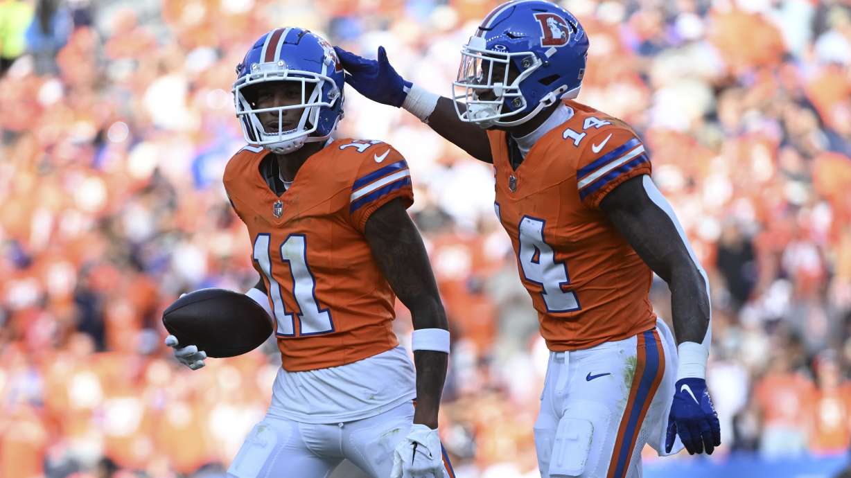 Denver Broncos wide receiver Josh Reynolds (11) celebrates his 9-yard reception for a touchdown with teammate wide receiver Courtland Sutton (14) during the second half of an NFL football game against the Las Vegas Raiders, Sunday, Oct. 6, 2024, in Denver.