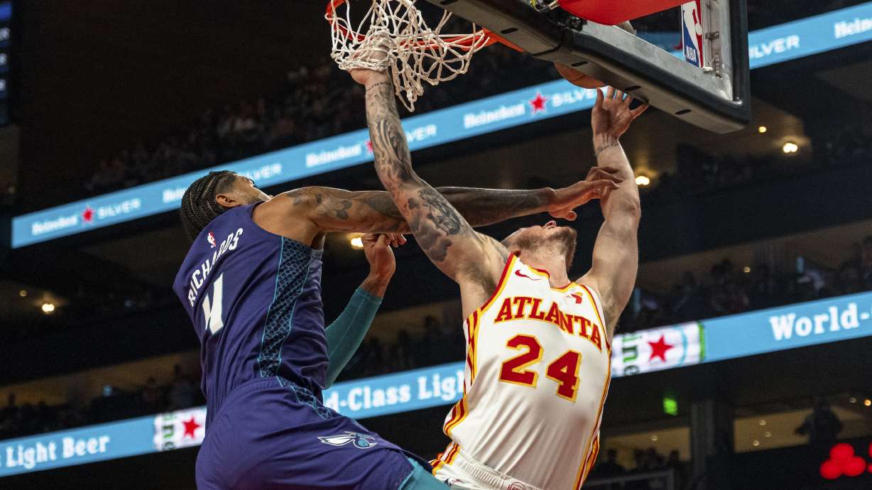Atlanta Hawks guard Garrison Mathews (24) attempts a layup but is fouled by Charlotte Hornets center Nick Richards (4) during the first half of an NBA basketball game, Friday, Oct. 25, 2024, in Atlanta.