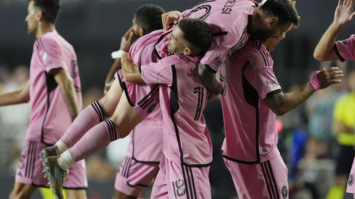 Inter Miami defender Jordi Alba (18) lifts Inter Miami forward Lionel Messi (10) after Alba scored a goal during the second half of match one of their MLS playoff opening round soccer match against Atlanta United, Friday, Oct. 25, 2024, in Fort Lauderdale, Fla.