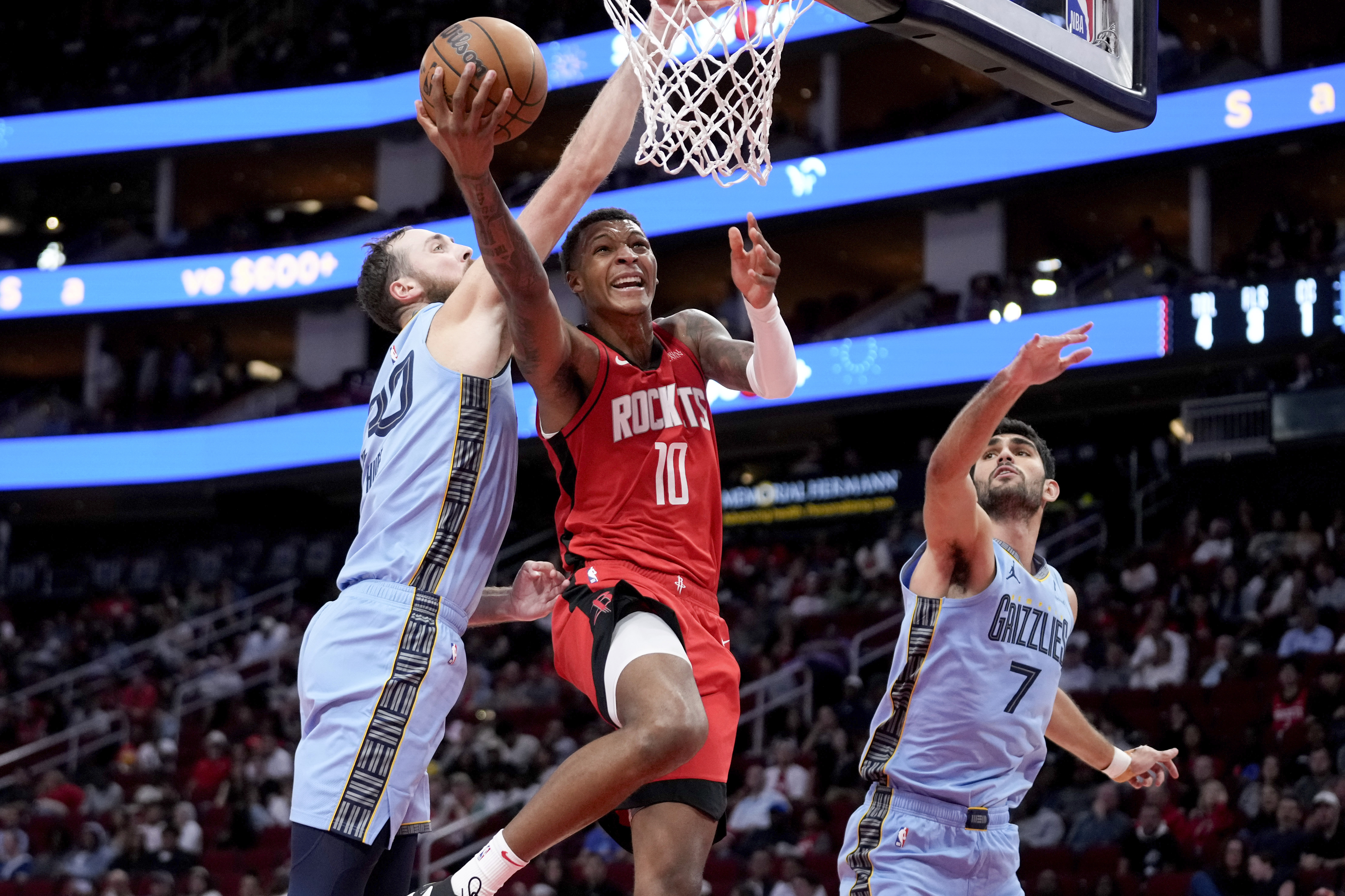 Houston Rockets forward Jabari Smith Jr. (10) goes up to shoot as Memphis Grizzlies center Jay Huff, left, and forward Santi Aldama (7) defend during the first half of an NBA basketball game Friday, Oct. 25, 2024, in Houston. 