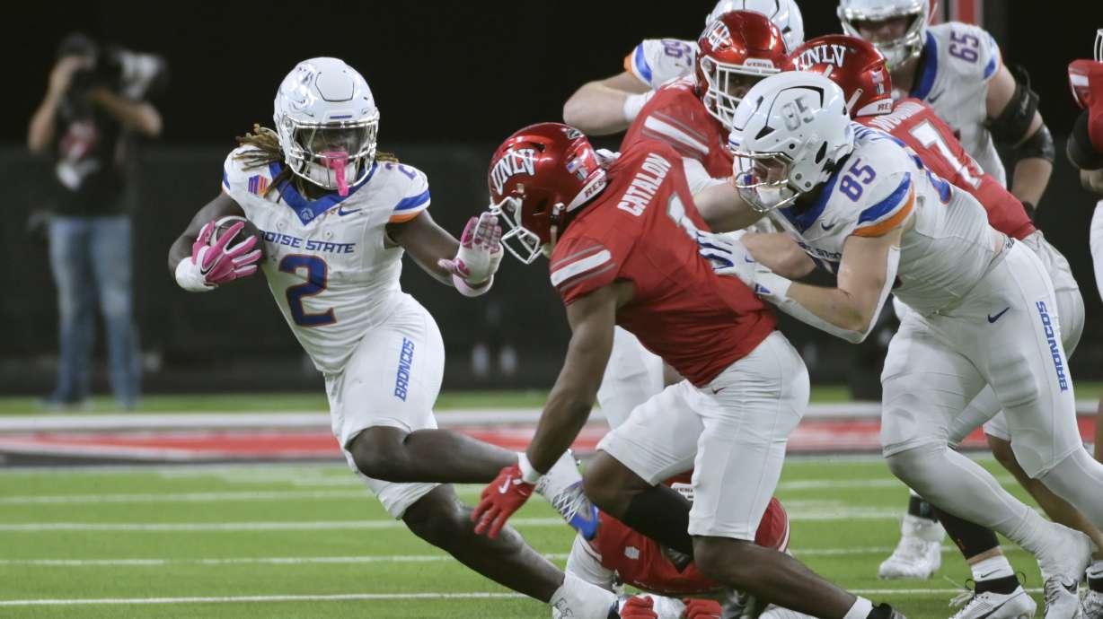 Boise State running back Ashton Jeanty (2) keeps UNLV defensive back Jalen Catalon (1) away during the first half of an NCAA college football game Friday, Oct. 25, 2024, in Las Vegas.