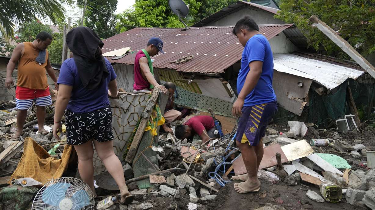 Residents try to recover personal belongings from their damaged home after a landslide triggered by Tropical Storm Trami recently struck Talisay, Batangas province, Philippines, Saturday.
